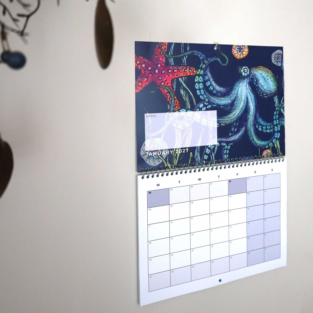 Cream Cornwall 2027 wall calendar open to January, featuring a colourful octopus and sea life illustration with a month-to-view planner and dedicated notes section.