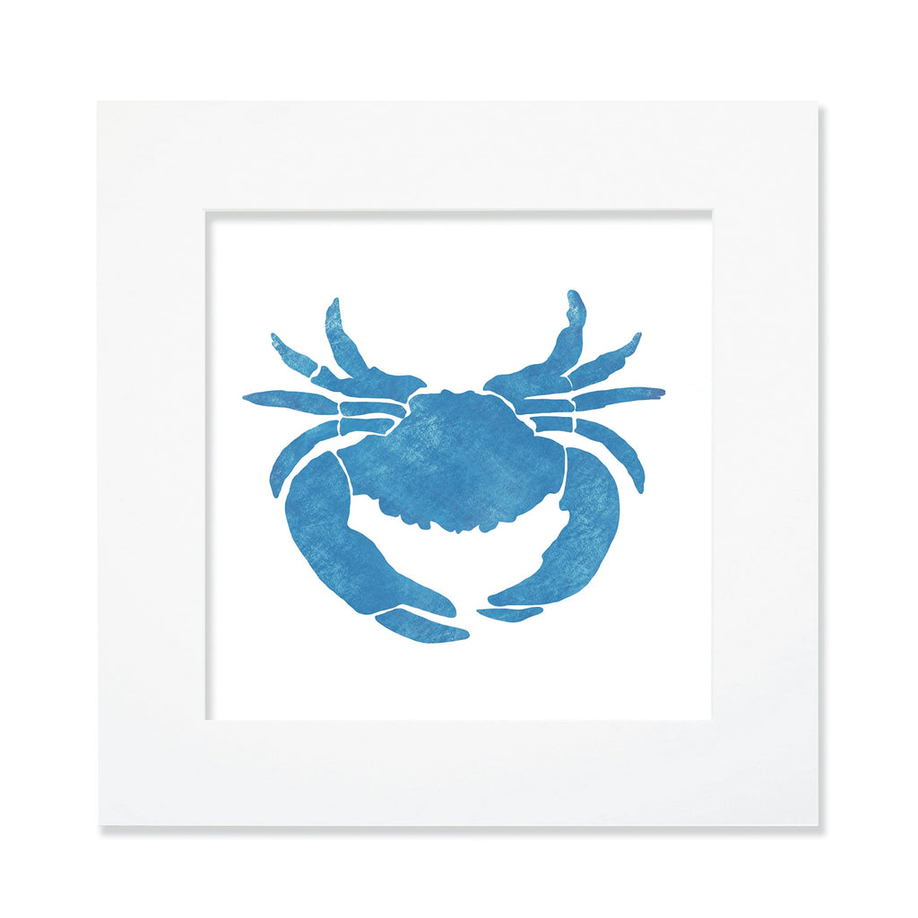 A 30cm square mounted artwork featuring a bold blue crab silhouette with a textured watercolor effect. The crab is centrally positioned against a crisp white background, enclosed within a white mount and frame. The design has a nautical and coastal-inspired aesthetic, making it a stylish piece for ocean-themed decor.