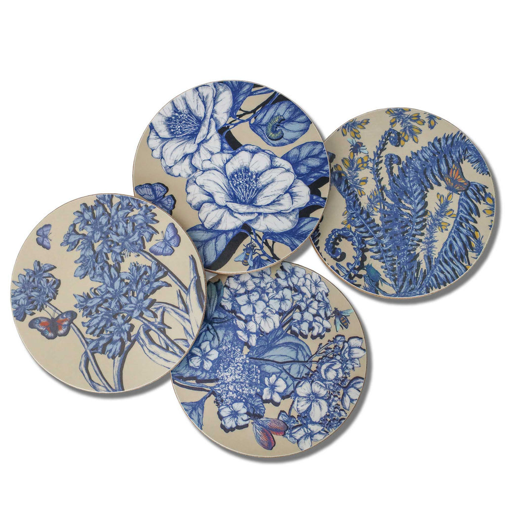 Set of four Cream Cornwall round botanical coasters featuring intricate blue floral and fern illustrations, with delicate butterflies and bees on a soft cream background. Each coaster showcases a different nature-inspired design.