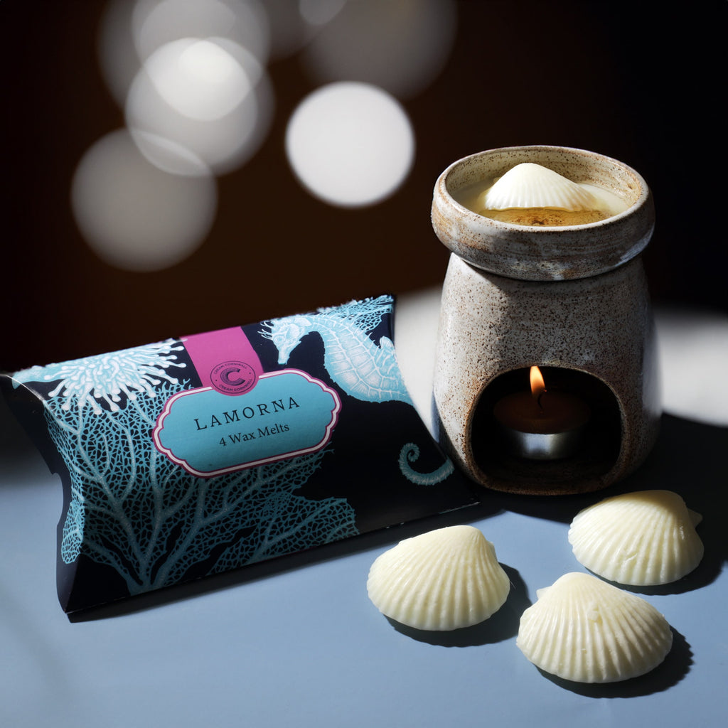 Lamorna wax melts packaging with a ceramic warmer and melts on a reflective surface.