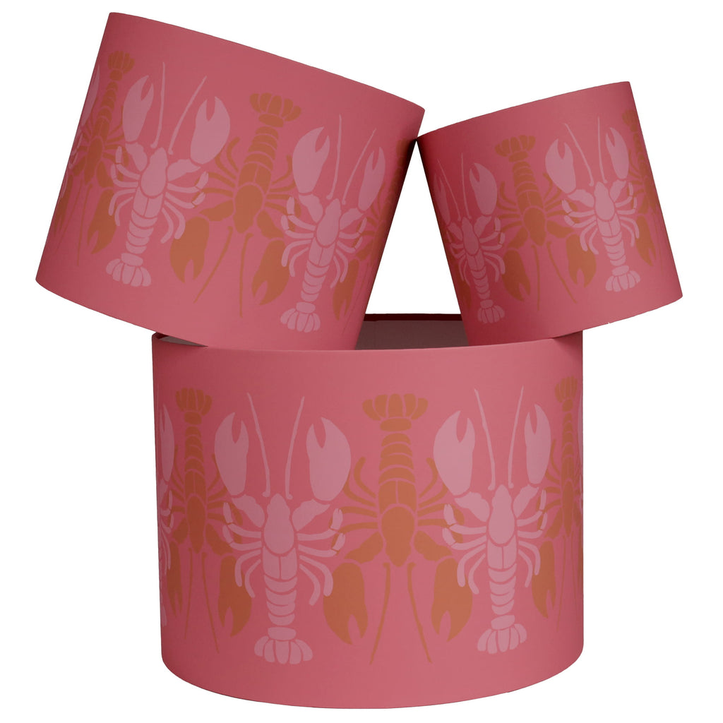 Pink cylindrical lampshades with lobster pattern on a white background