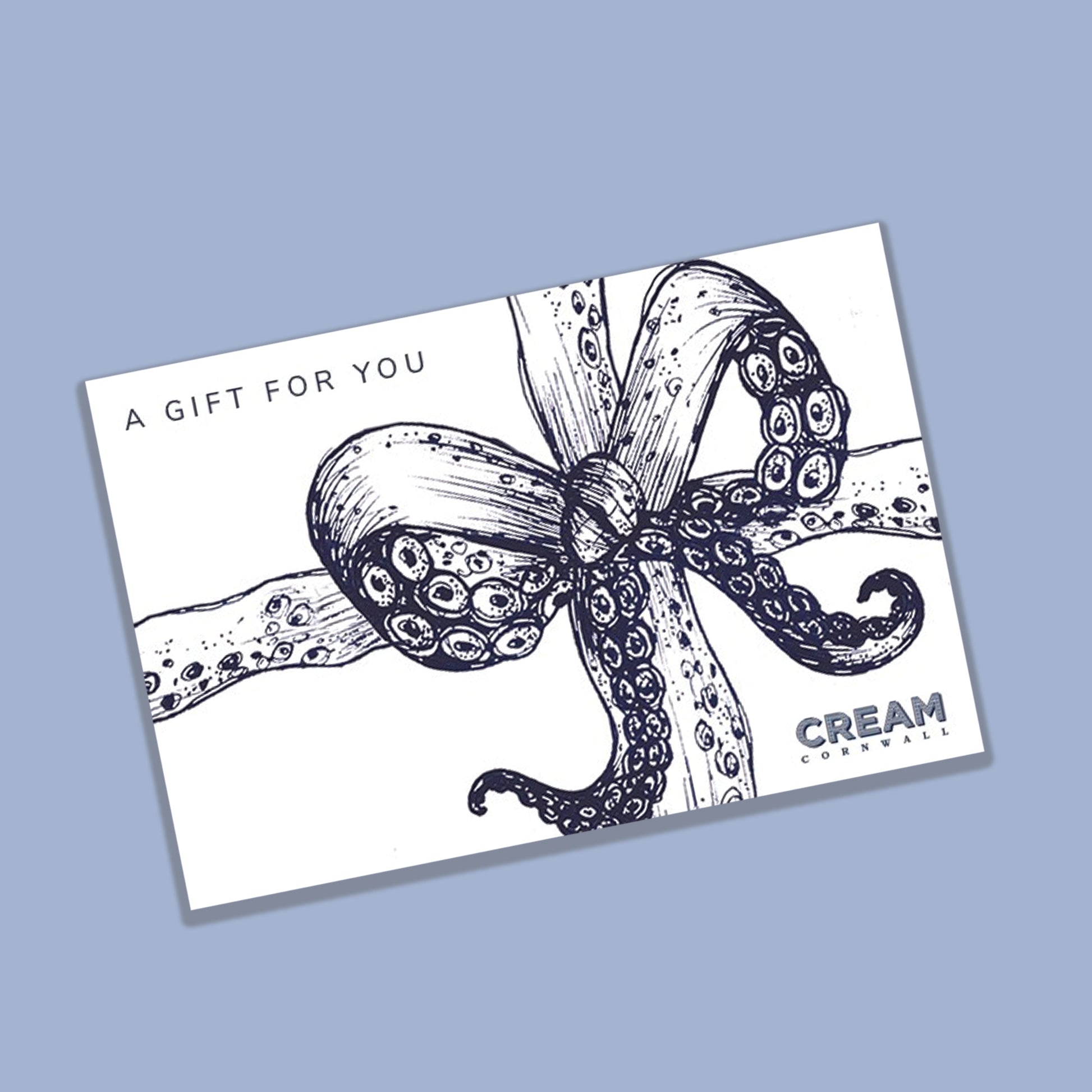 A gift card from Cream Cornwall featuring a nautical-inspired illustration of an octopus tentacle tied into a bow, drawn in a detailed navy blue sketch style. The card has the text 'A GIFT FOR YOU' in the top left corner and 'CREAM CORNWALL' in the bottom right, set against a white background with a light blue backdrop.