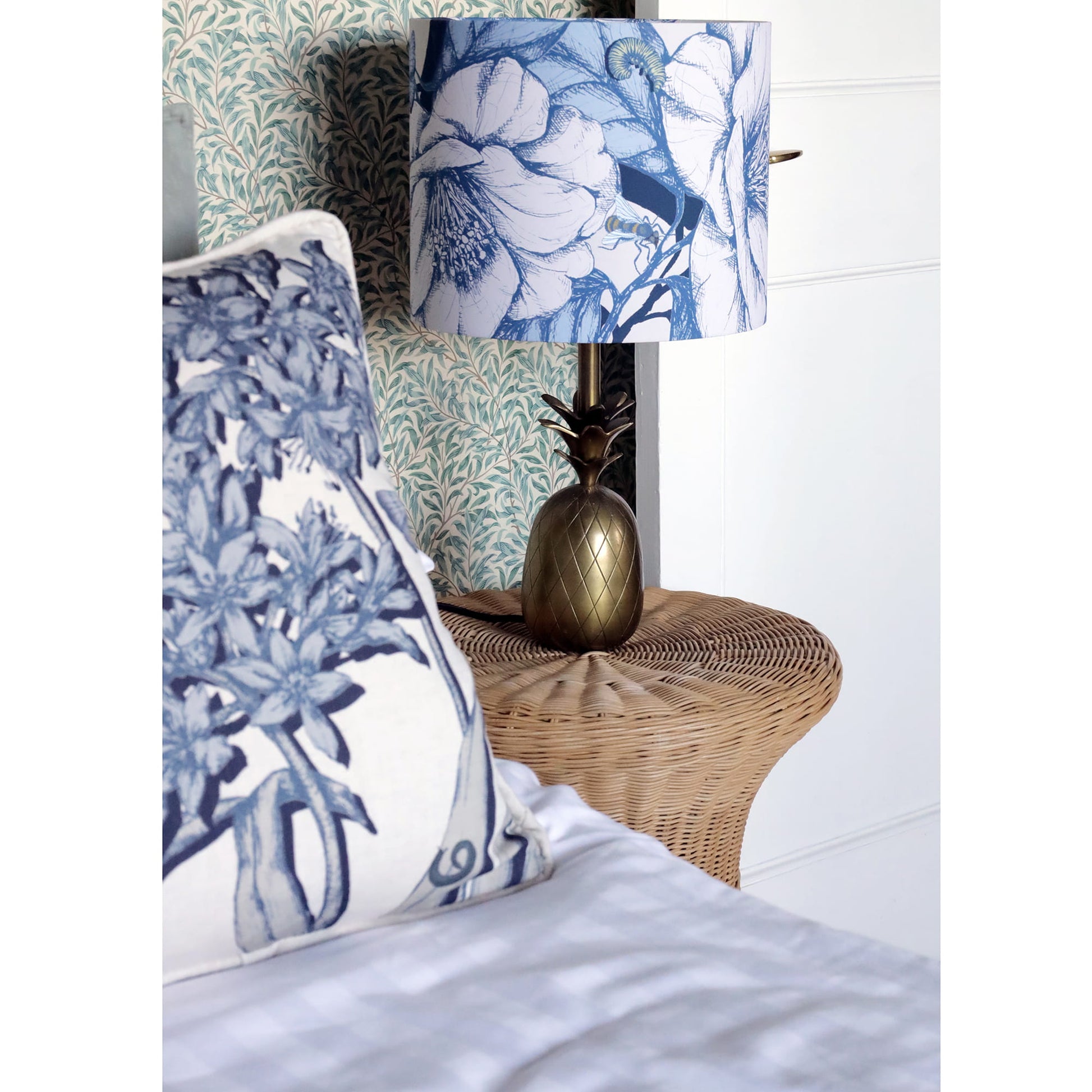 Decorative pillow and camelia lamp with floral pattern on a bed in a bedroom setting.
