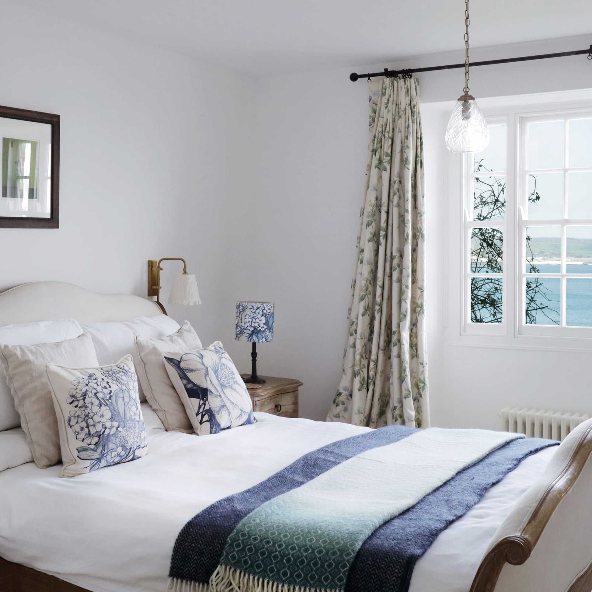 Cozy bedroom with a bed, lamp, and window with curtains.