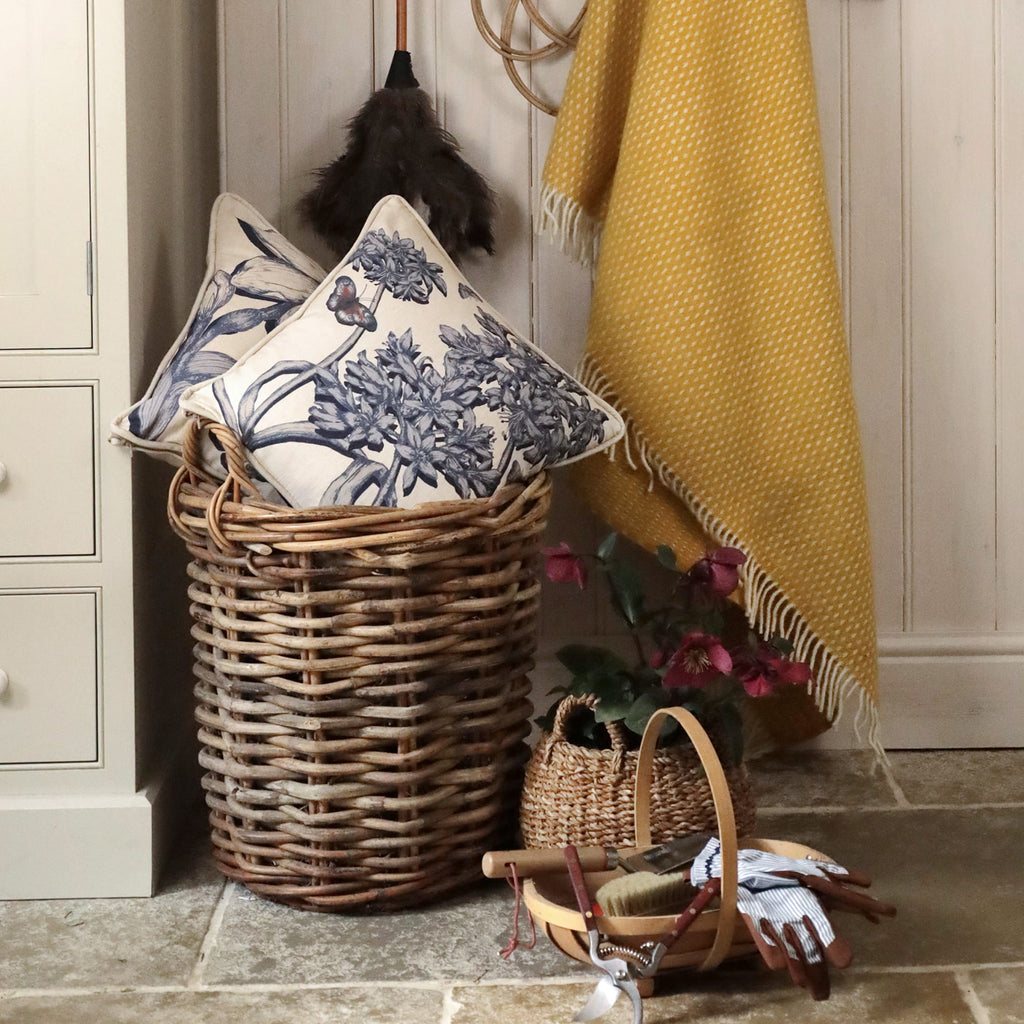Decorative pillows, basket, and blanket in a home setting