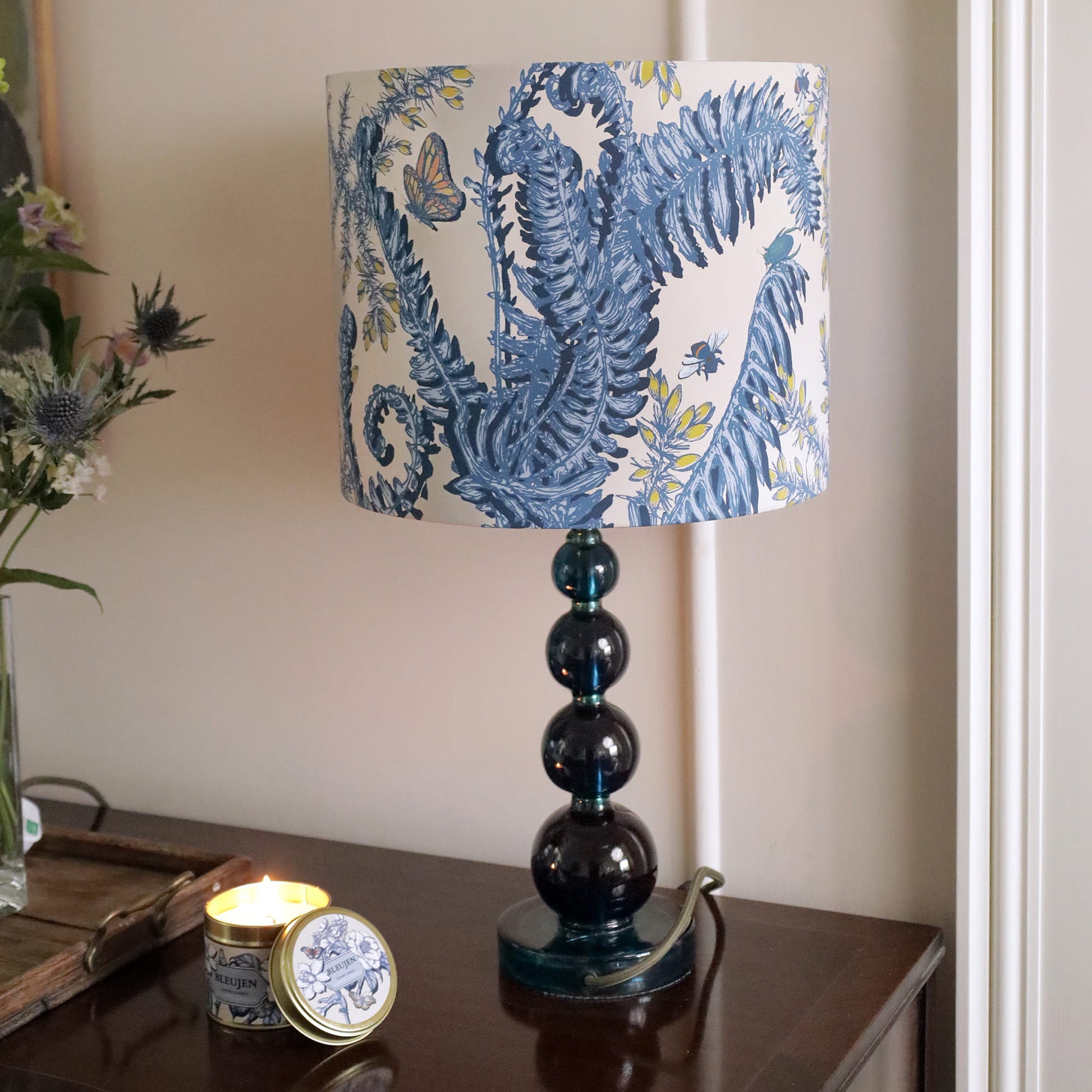 Table lamp with decorative blue and white shade on a wooden surface.