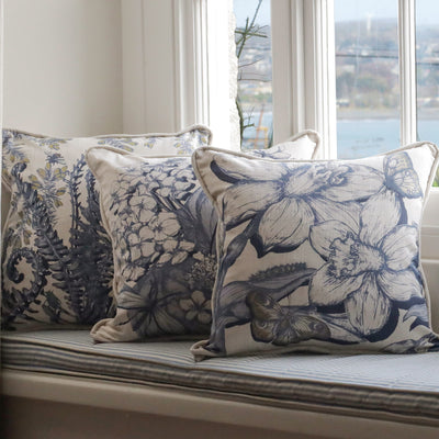 Cornish floral  patterned cushions on a window seat with a scenic view outside.