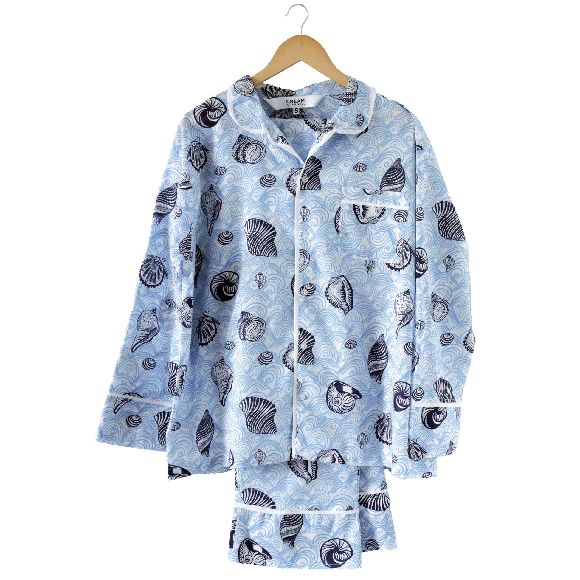 Light blue pajama set with shell pattern on a hanger against a white background