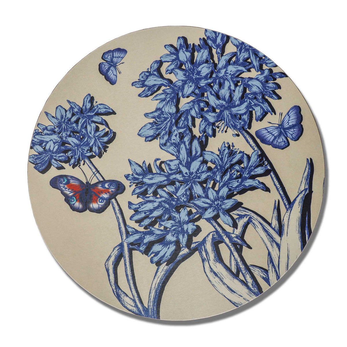 Round decorative placemat featuring an intricate botanical illustration of clustered blue flowers, long flowing leaves and delicate stems on a soft beige background. Three butterflies flutter among the blooms, including a striking blue butterfly with vibrant orange and turquoise markings. The detailed, hand-drawn design combines deep indigo and pale blue tones, creating an elegant, nature-inspired pattern against a clean white background.
