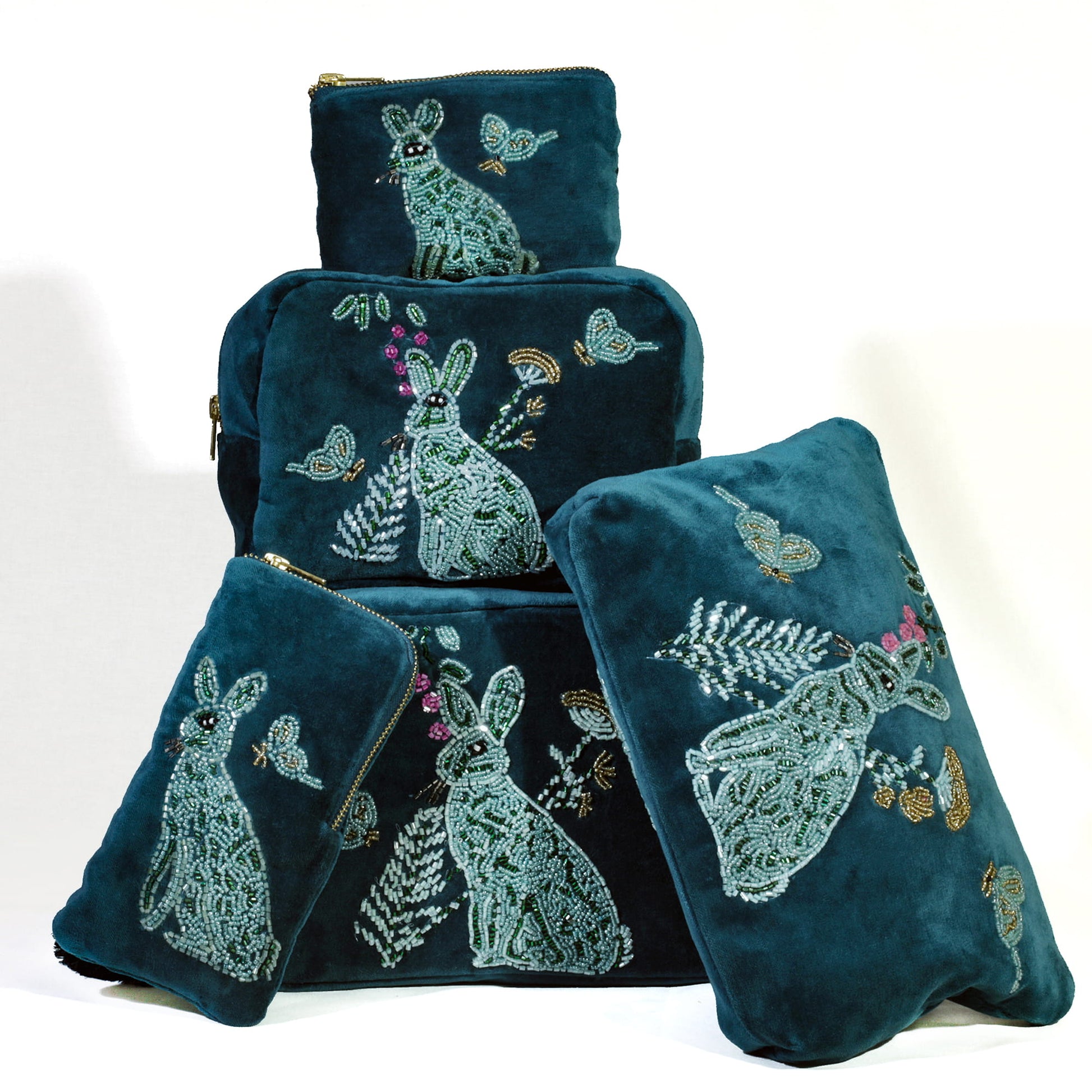 Set of  teal pouches with beaded designs on a white background.