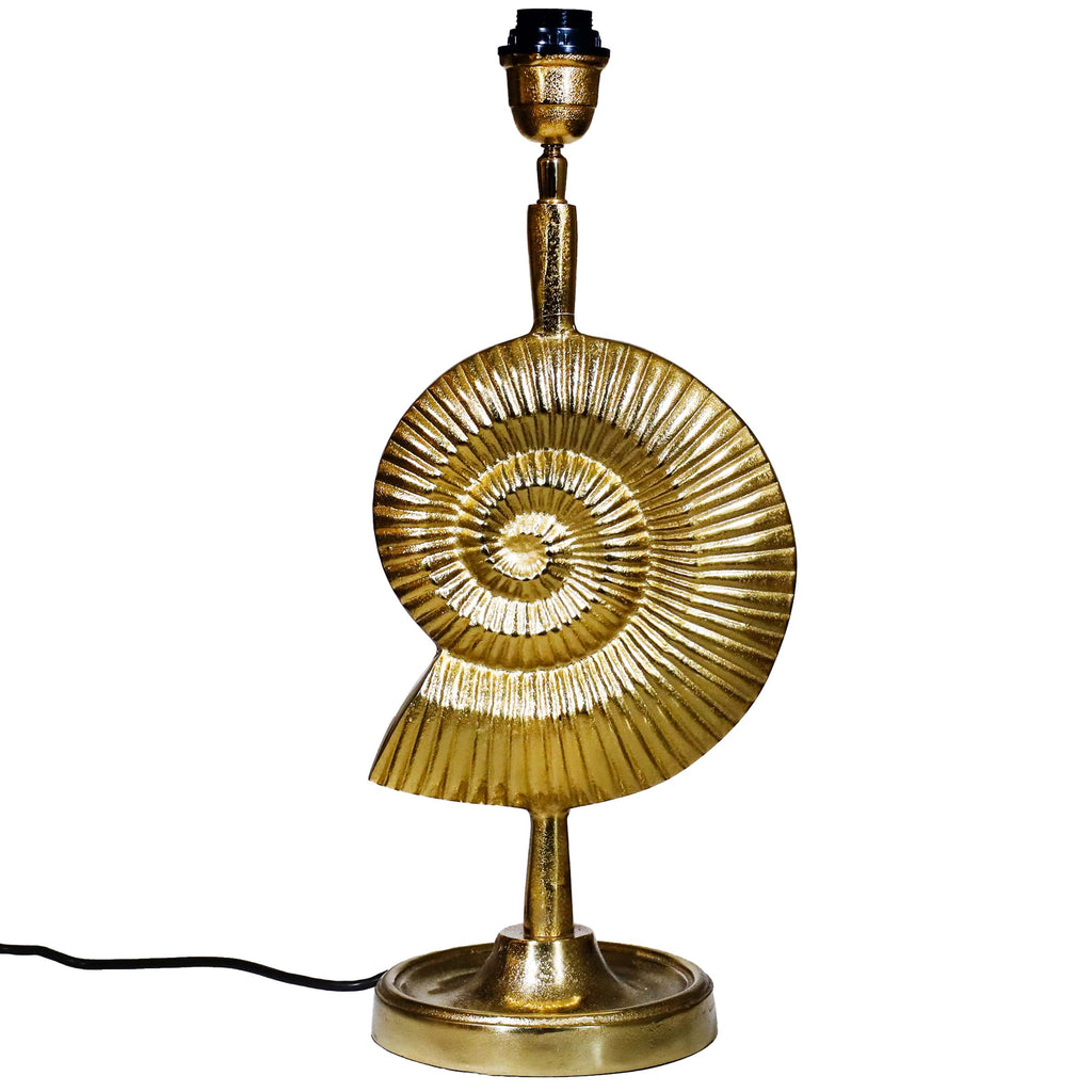 A gold ammonite-shaped lamp base featuring a textured spiral shell design on a round pedestal, with a black lamp fitting and a visible black power cord.