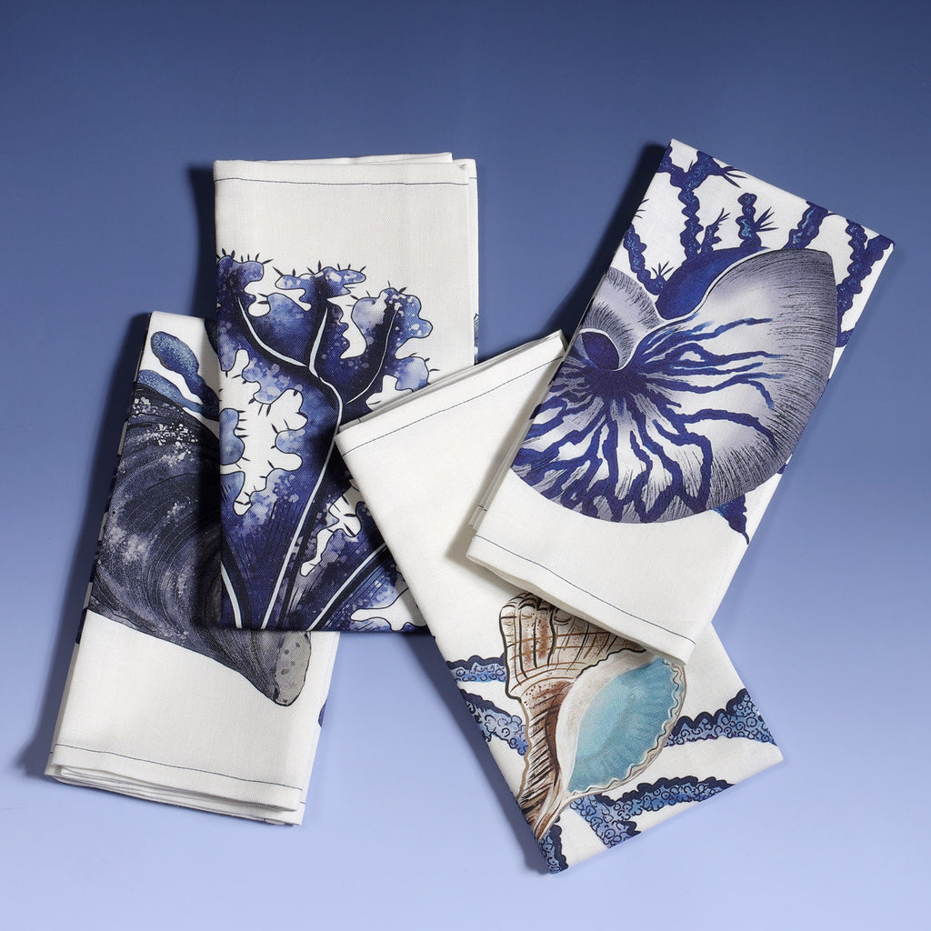 Set of 4 off white linen napkins with hand drawn beachcomber illustrations,set of four different ones folded on top of each other