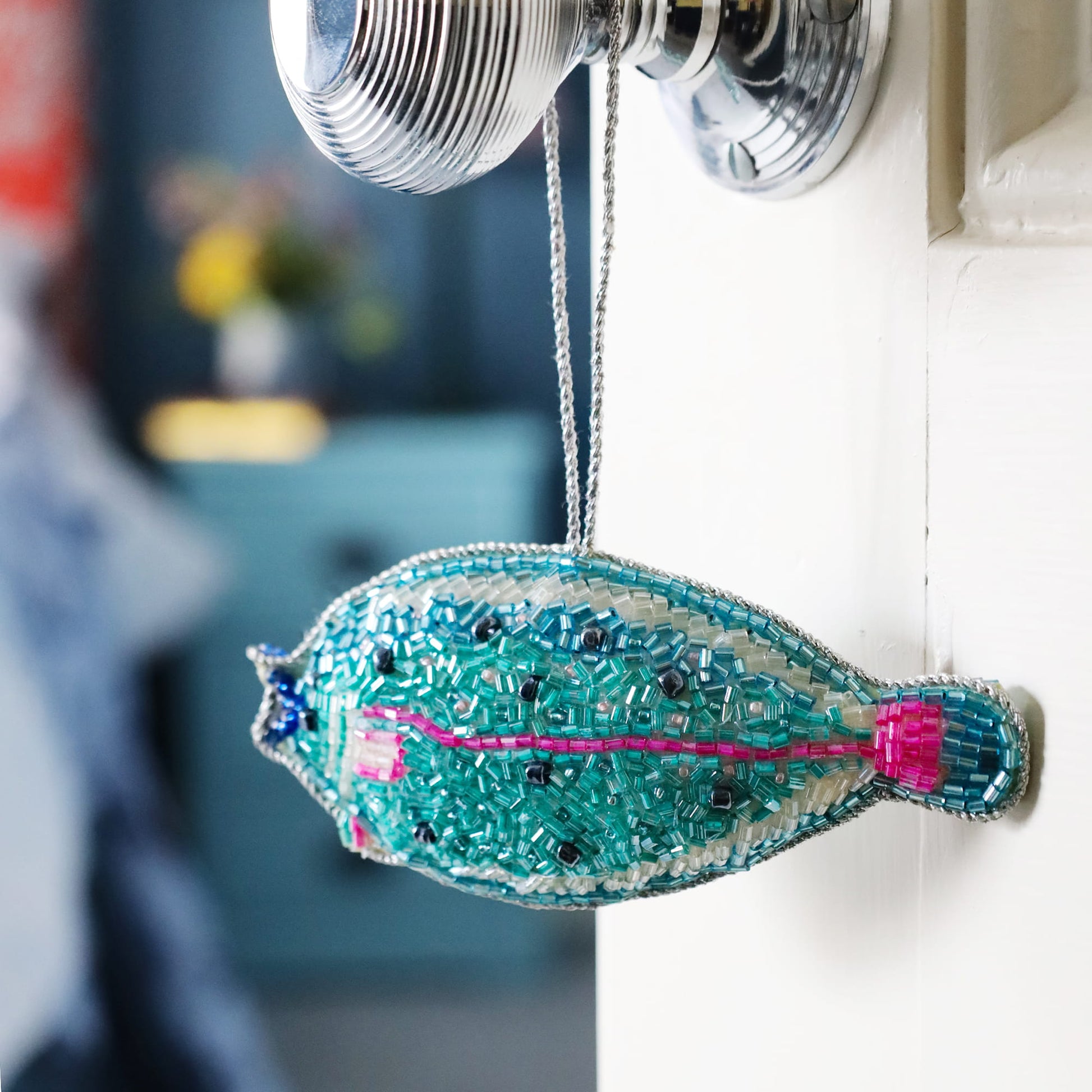 Decorative fish ornament hanging on a wall with a blurred background