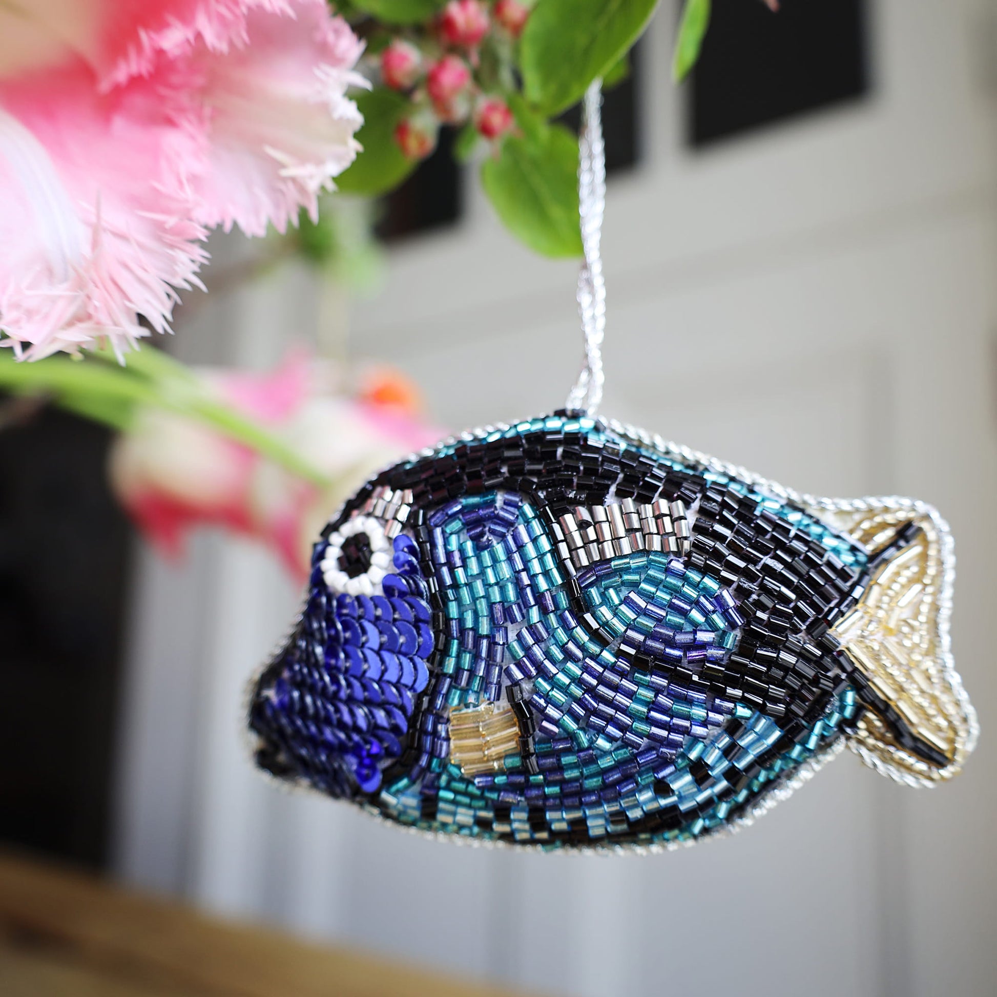 Beaded fish ornament with flowers in the background