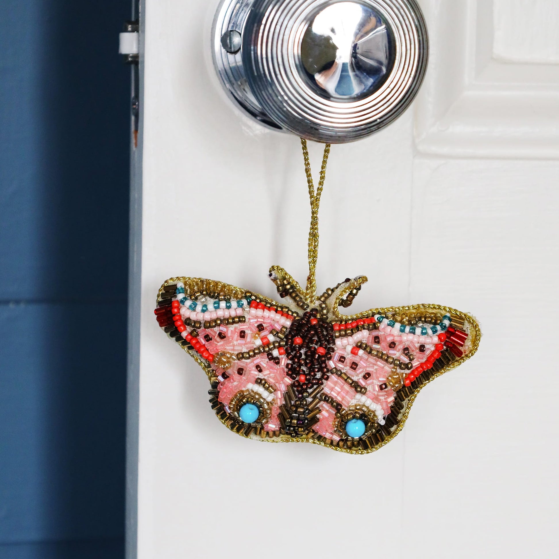 Decorative butterfly ornament hanging on a door handle.