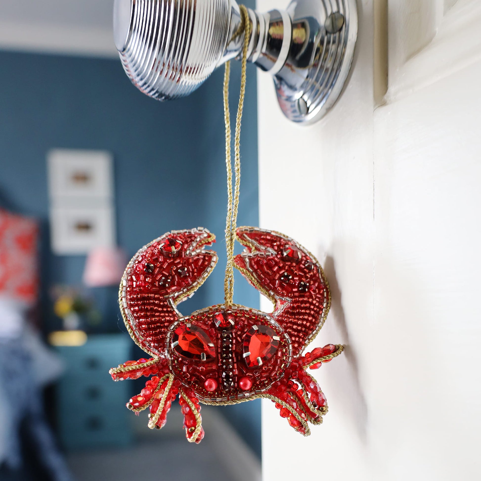 Decorative red crab ornament hanging on a door handle.