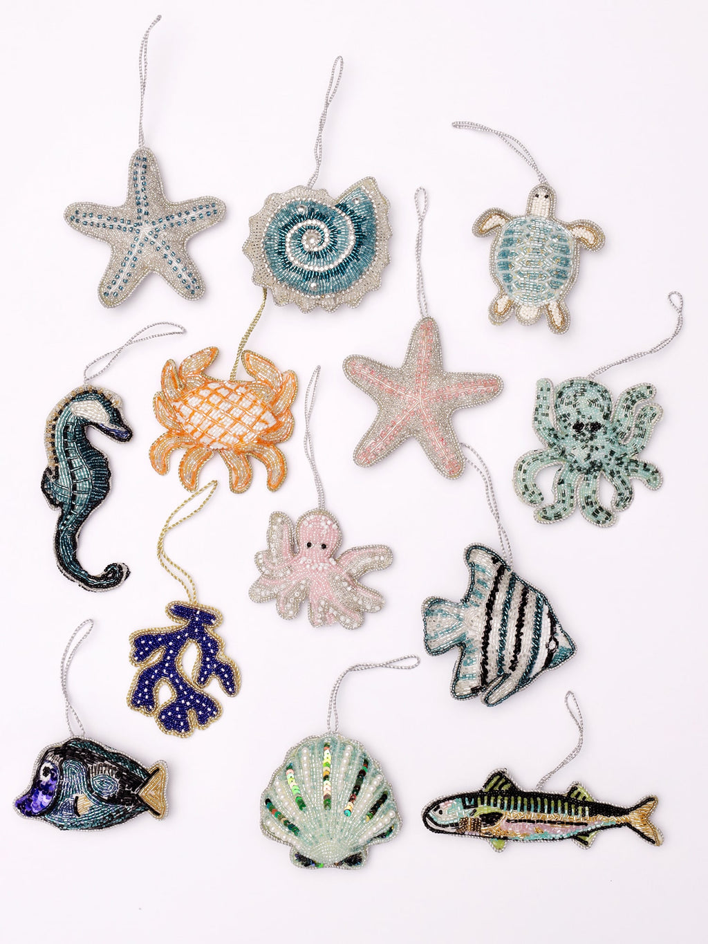 A vibrant collection of intricately beaded marine-themed ornaments, featuring a variety of ocean creatures and shells. This set includes a shimmering starfish, a coiled seashell, a charming turtle, a delicate seahorse, a lively crab, a playful octopus, a detailed angelfish, a scallop shell, a bold fish, and a striking piece of coral. Each ornament is adorned with fine beadwork, metallic accents, and eye-catching colors, bringing the underwater world to life. Perfect for adding a touch of seaside elegance an