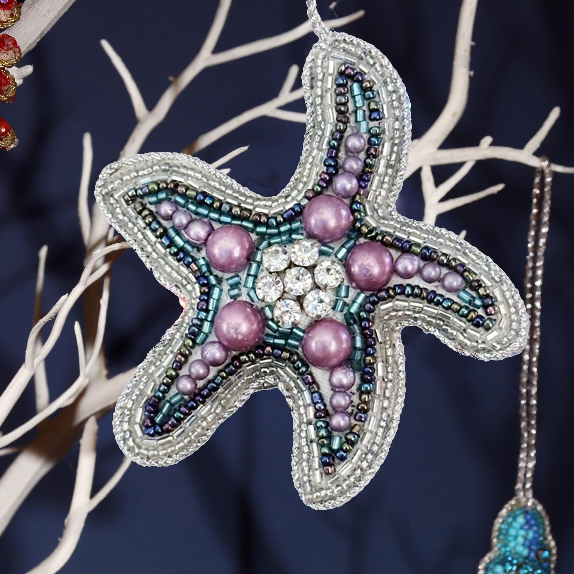 Decorative starfish ornament with beads on a dark background