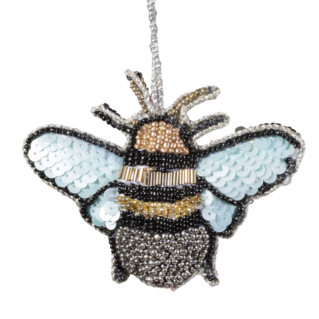 Bee-shaped ornament with sequin wings on a white background