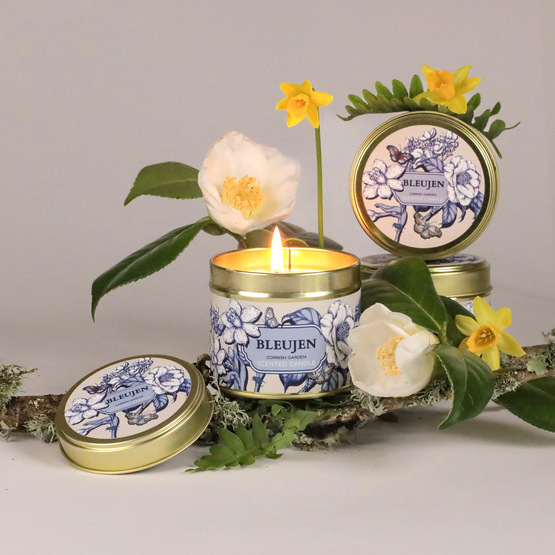 Bleujen candle with floral decorations on a neutral background
