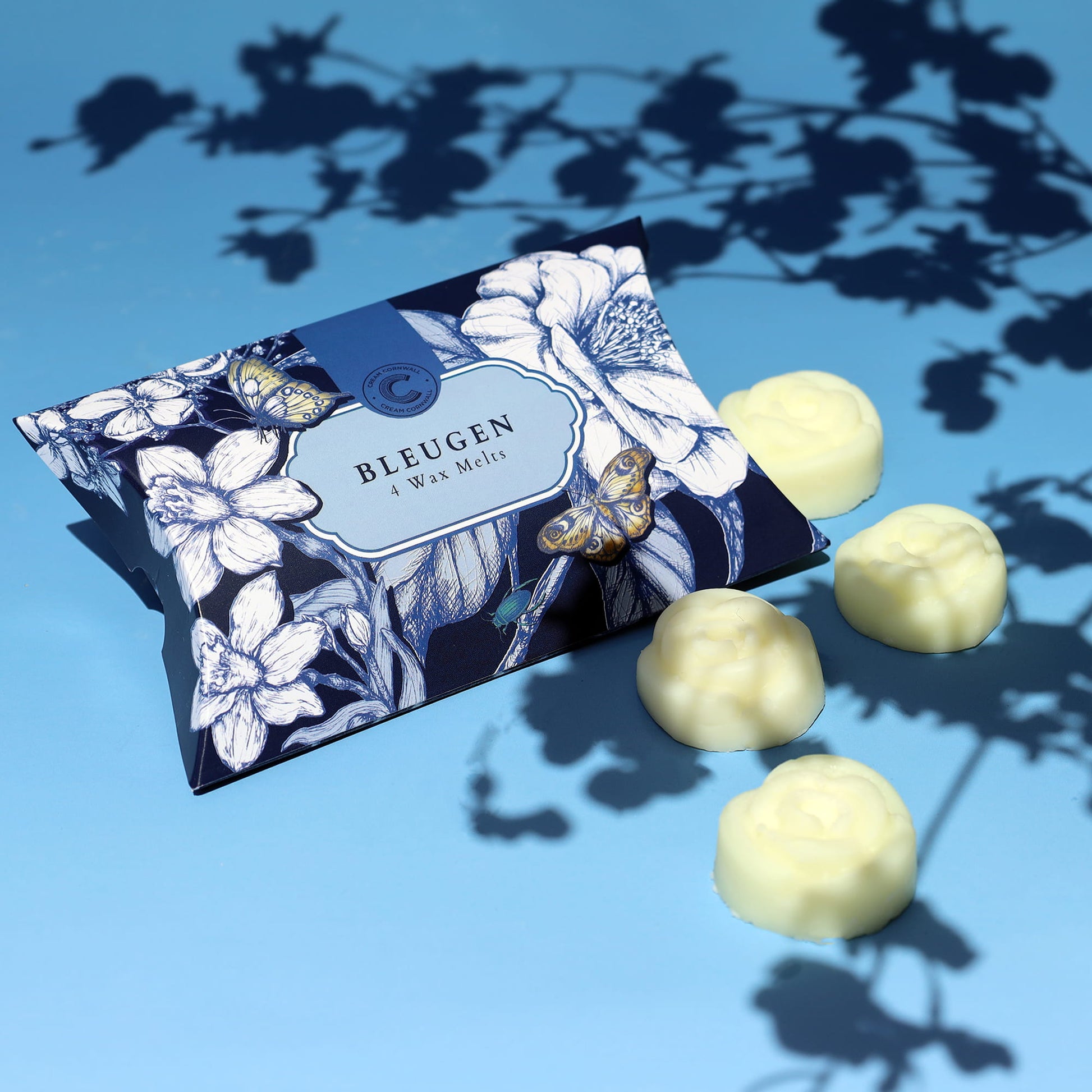 Bleujen wax melt product packaging with white flower shaped wax melts on a blue background