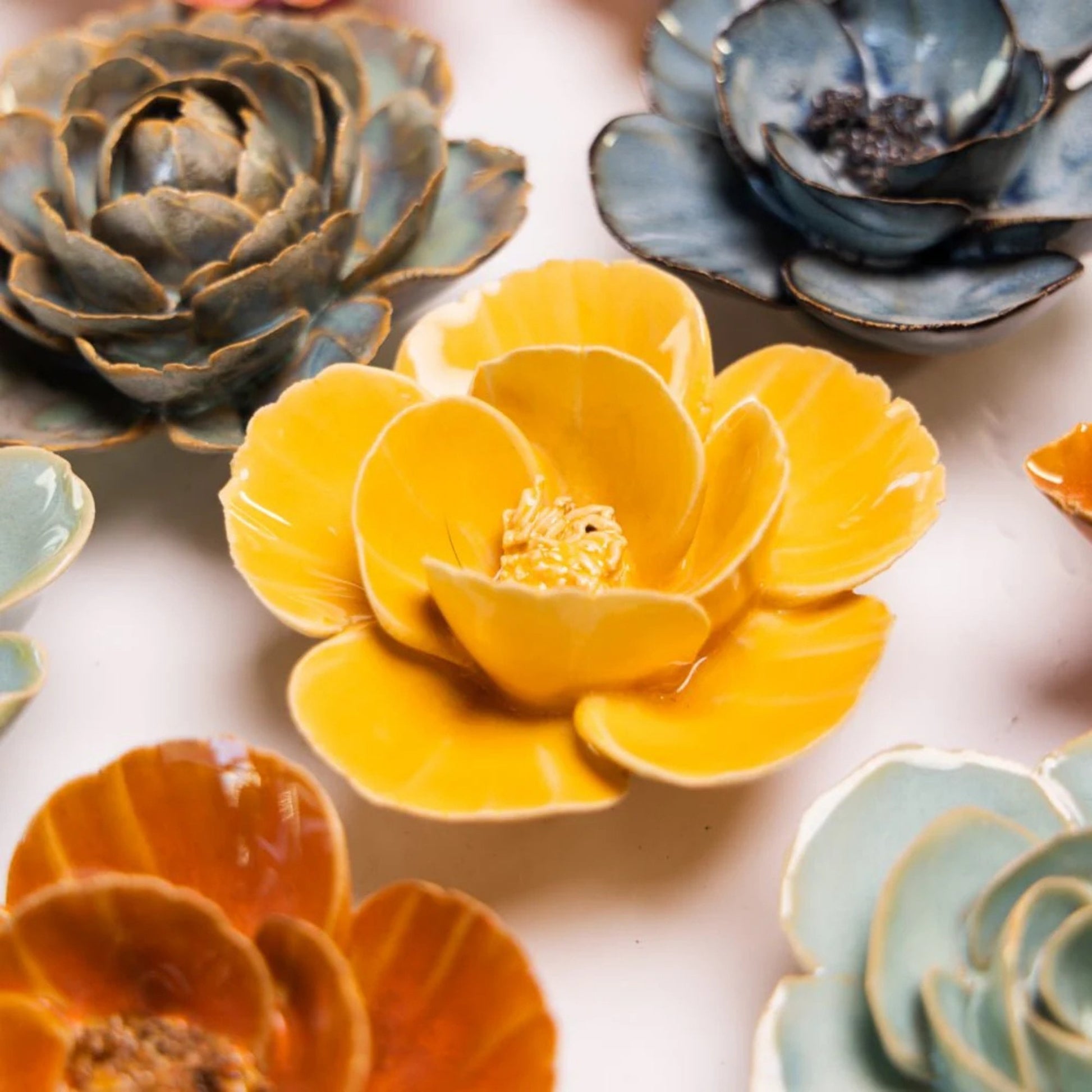Colourful ceramic flower-shaped ceramic flowers on a light background