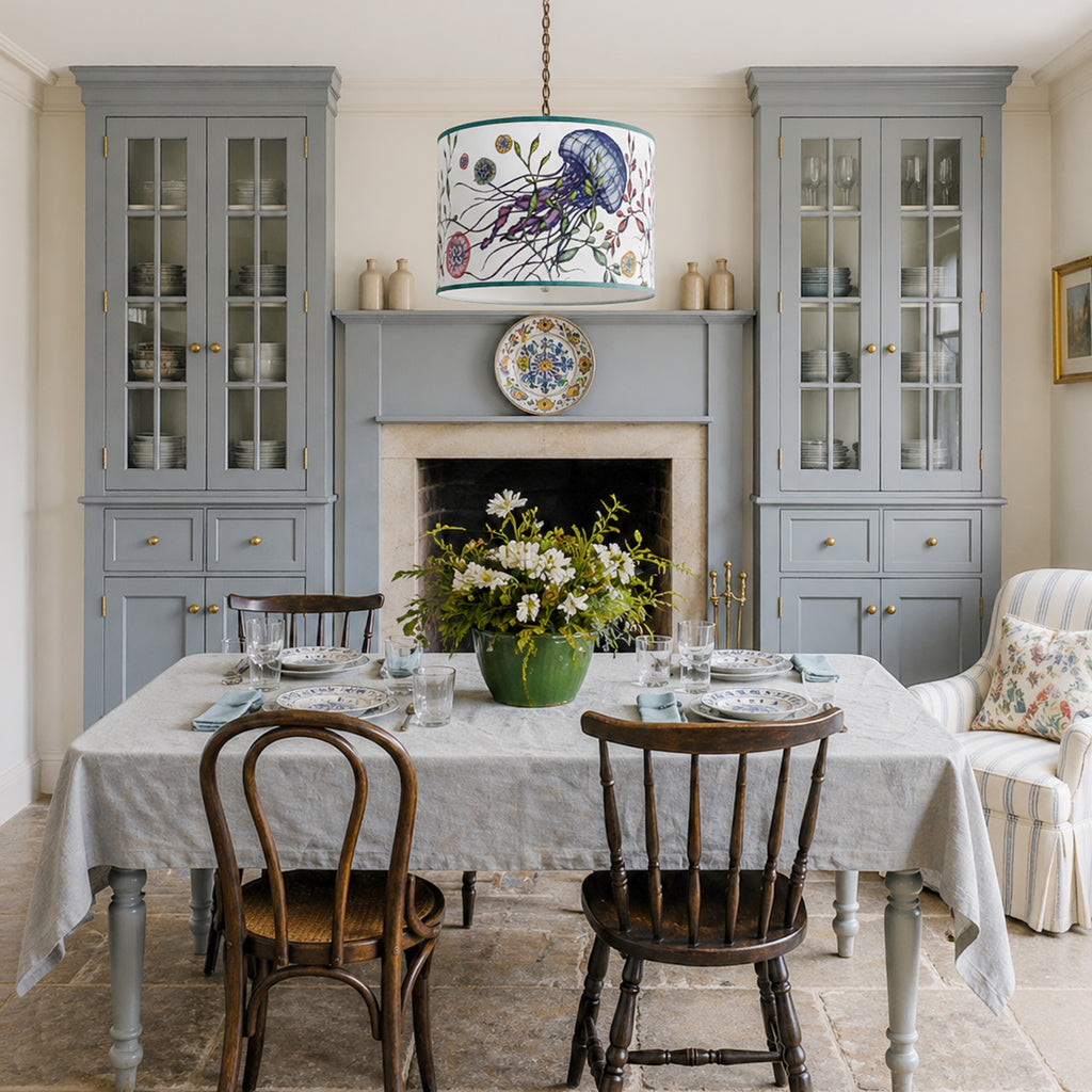 Dining room with grey cabinets, floral pendant light, and wooden chairs.
