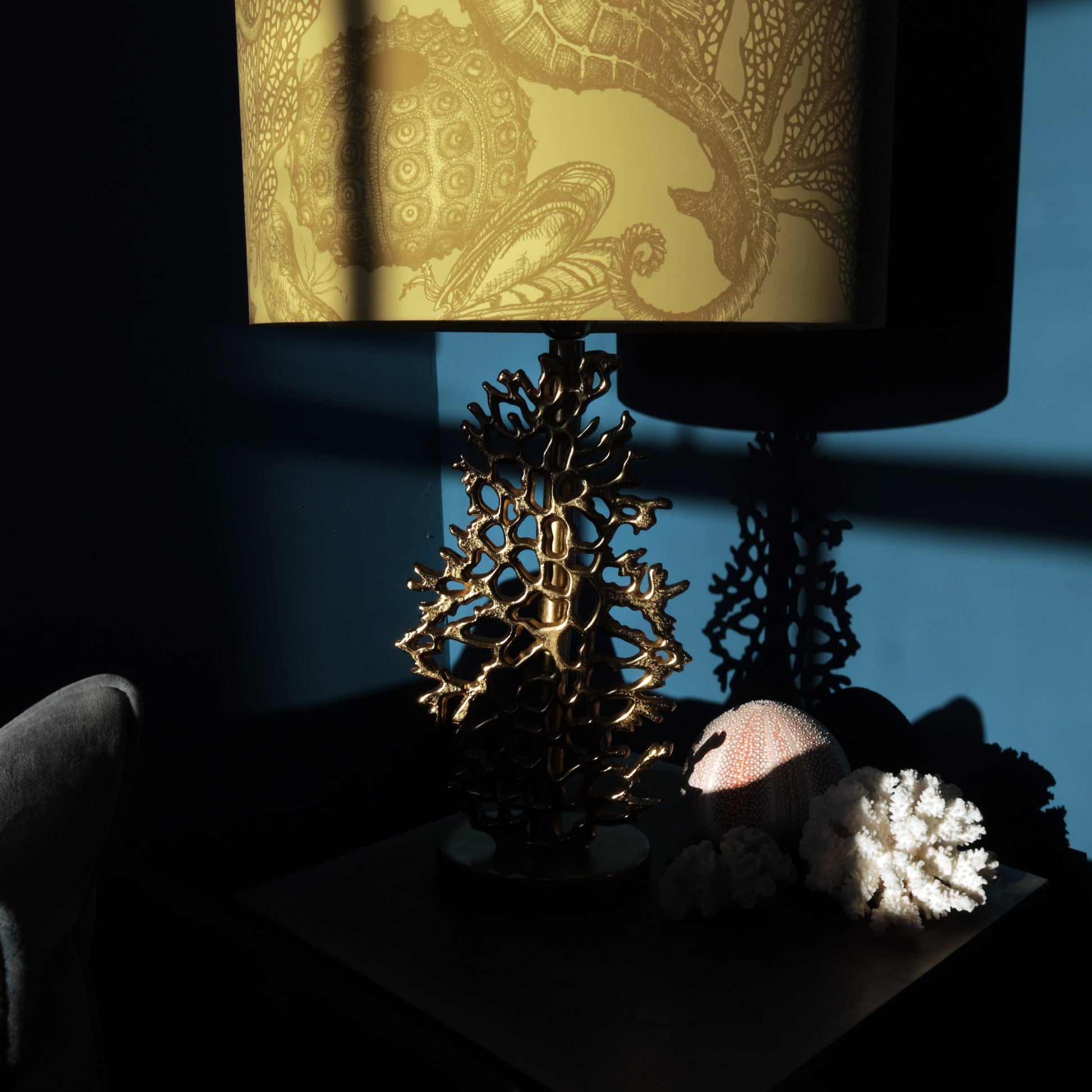 Decorative lamp with a gold coral design on a dark surface