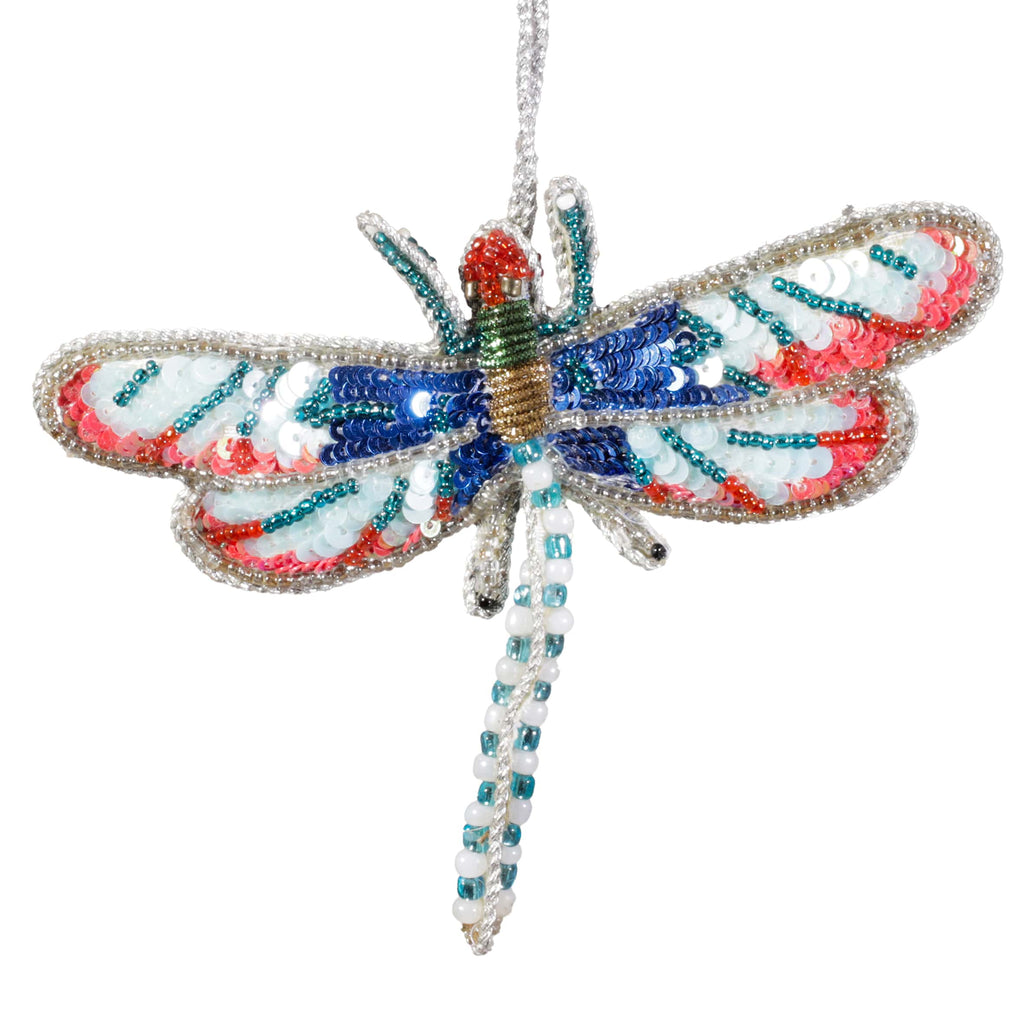 A beaded dragonfly decoration with iridescent wings in shades of blue, red, white, and green, detailed with sequins and silver edging, hanging by a silver thread.