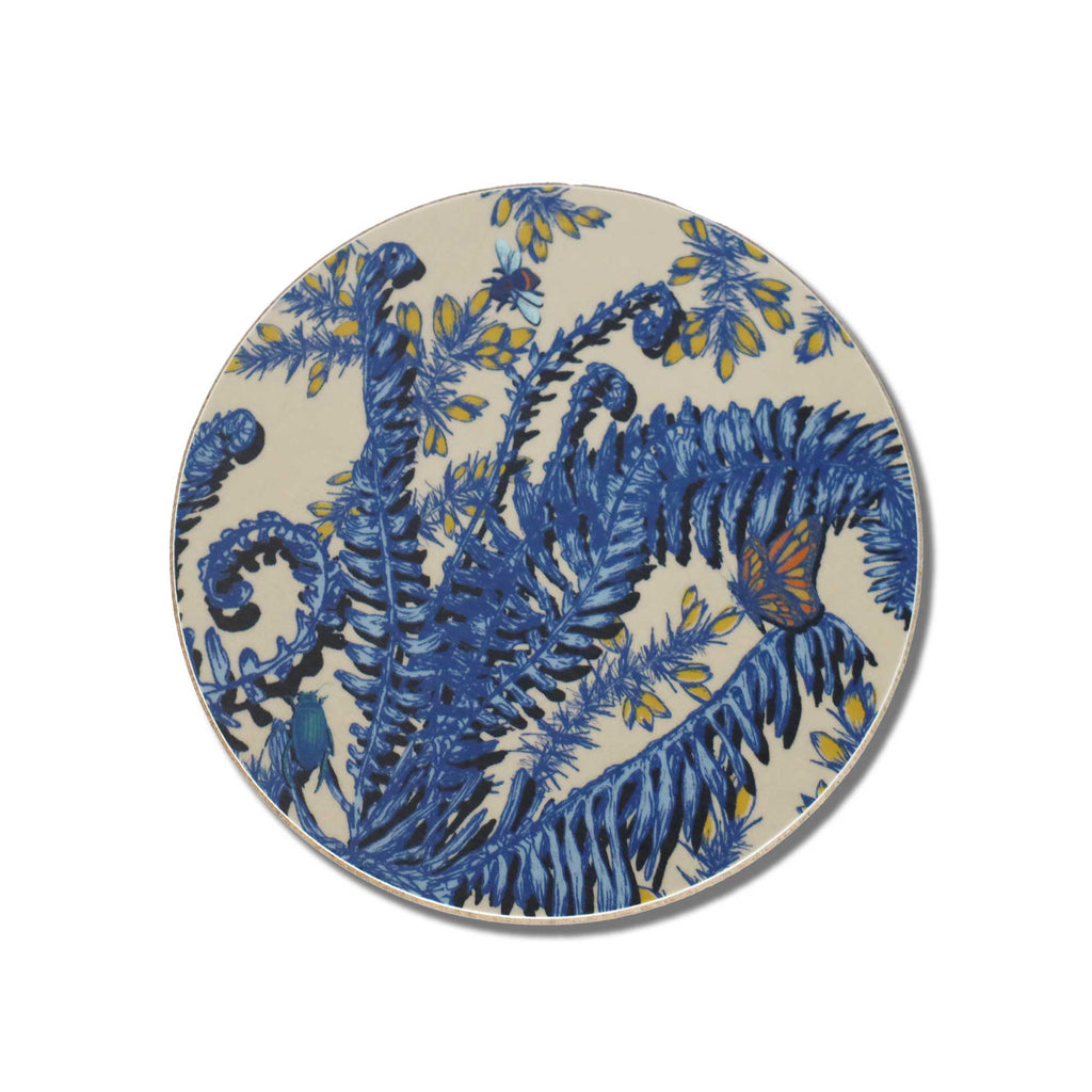 
Cream Cornwall round placemat featuring intricate blue fern illustrations, curling fronds, delicate yellow flowers, a colourful orange and blue butterfly, and small insects on a soft cream background, photographed against a clean white backdrop.