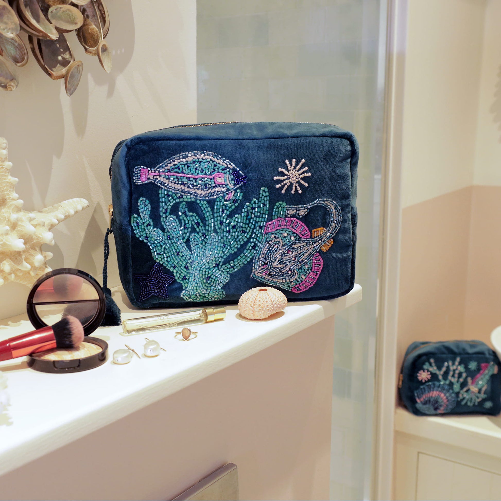 Decorative makeup bag with ocean-themed beading on a vanity.