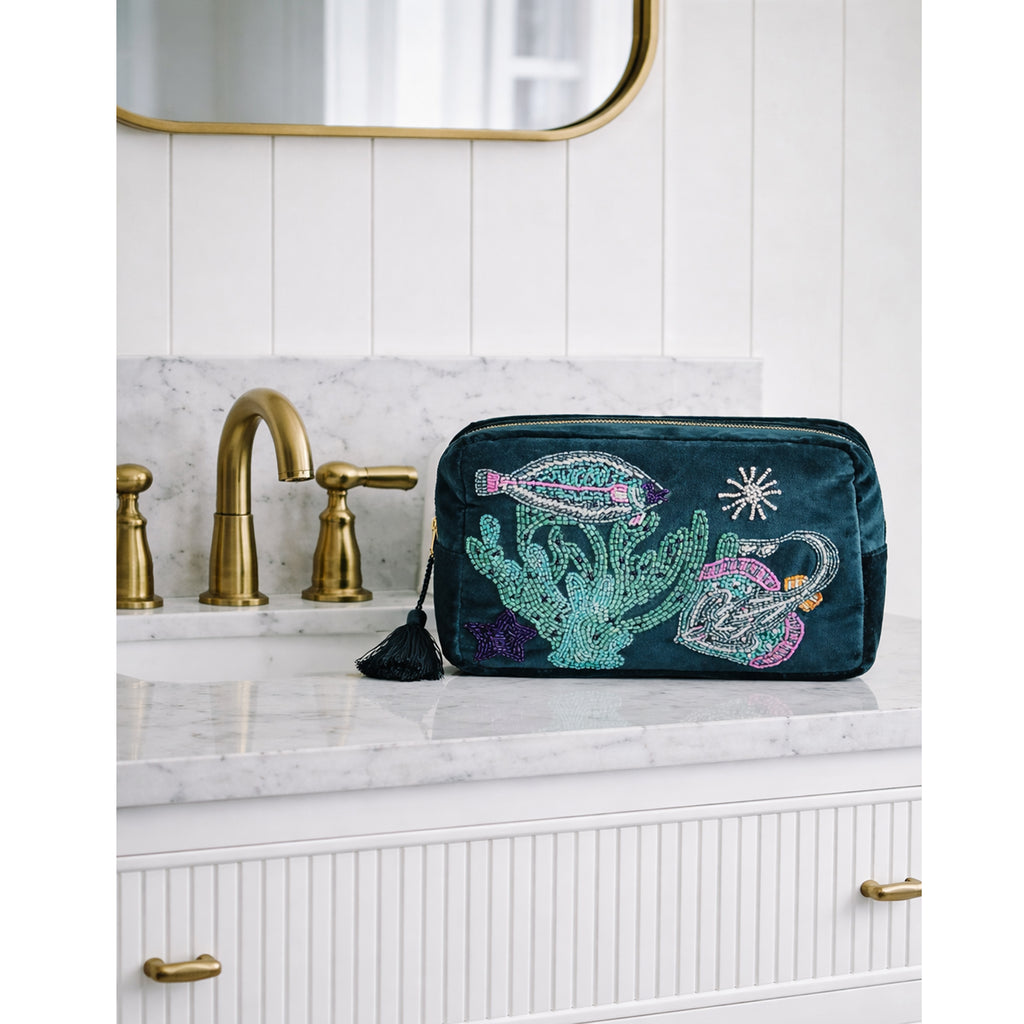 Teal makeup bag with flat fish & skate design on a bathroom counter