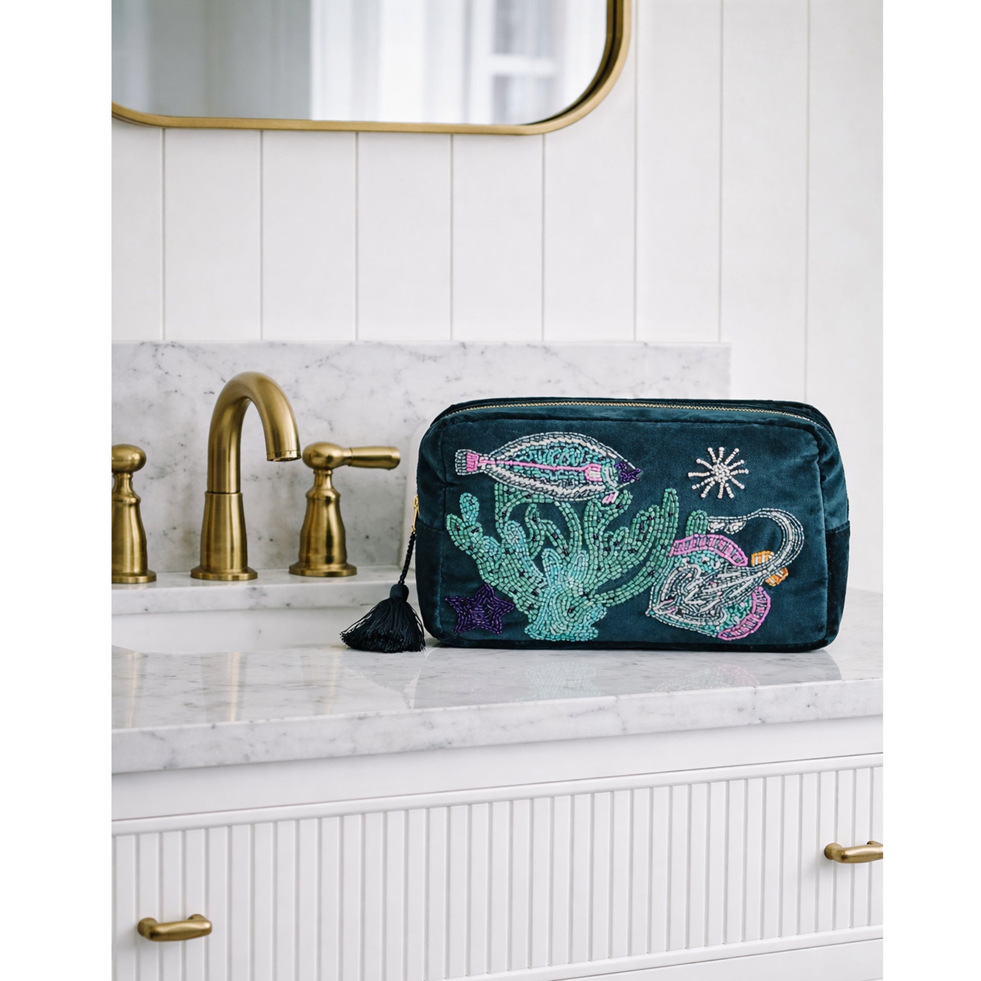 Teal makeup bag with flat fish & skate design on a bathroom counter