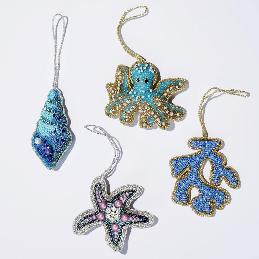 Set of four decorative ornaments shaped like an octopus, shell, starfish, and leaf on a white background.