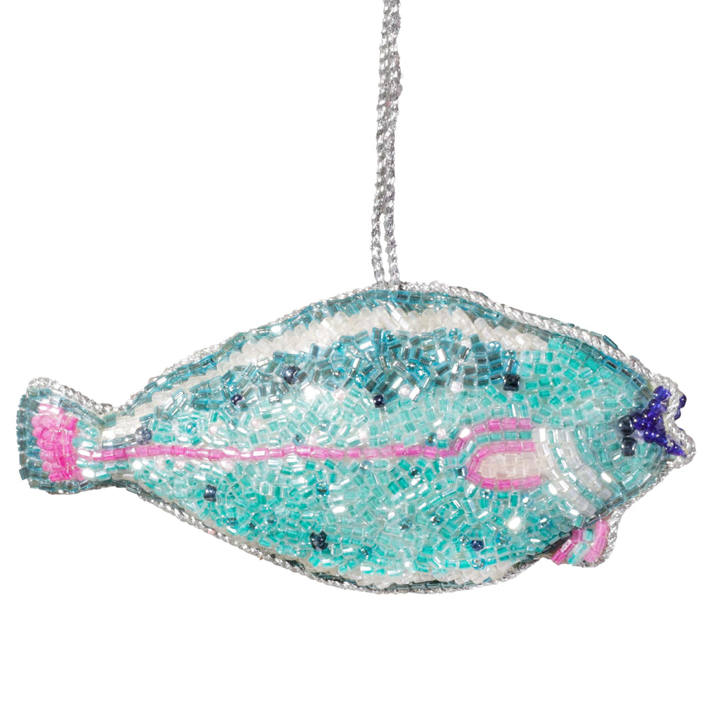 Decorative fish ornament with sequins and beads on a white background