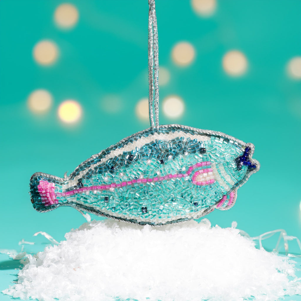 Decorative fish ornament with sequins on a turquoise background