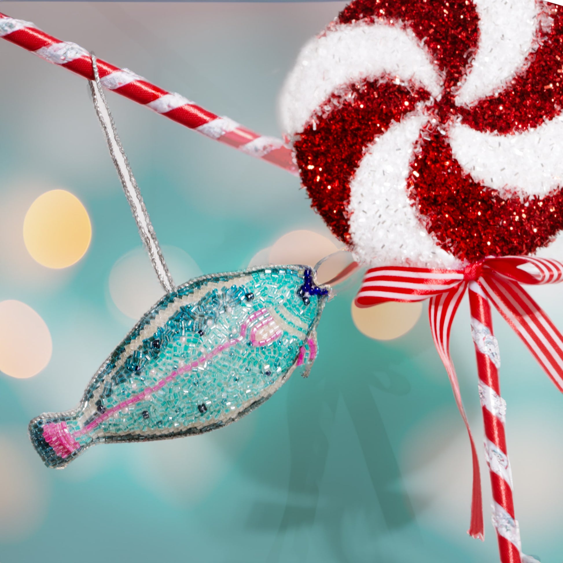Decorative fish ornament and candy cane against a blurred festive background