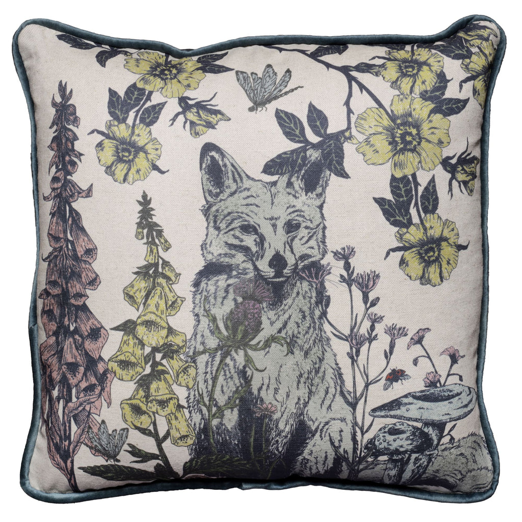 Square cushion featuring a detailed illustration of a fox surrounded by wildflowers, including foxgloves and yellow blossoms, along with mushrooms, a butterfly, and a bee. The design is set on a natural linen-coloured background with soft blue velvet piping around the edges.