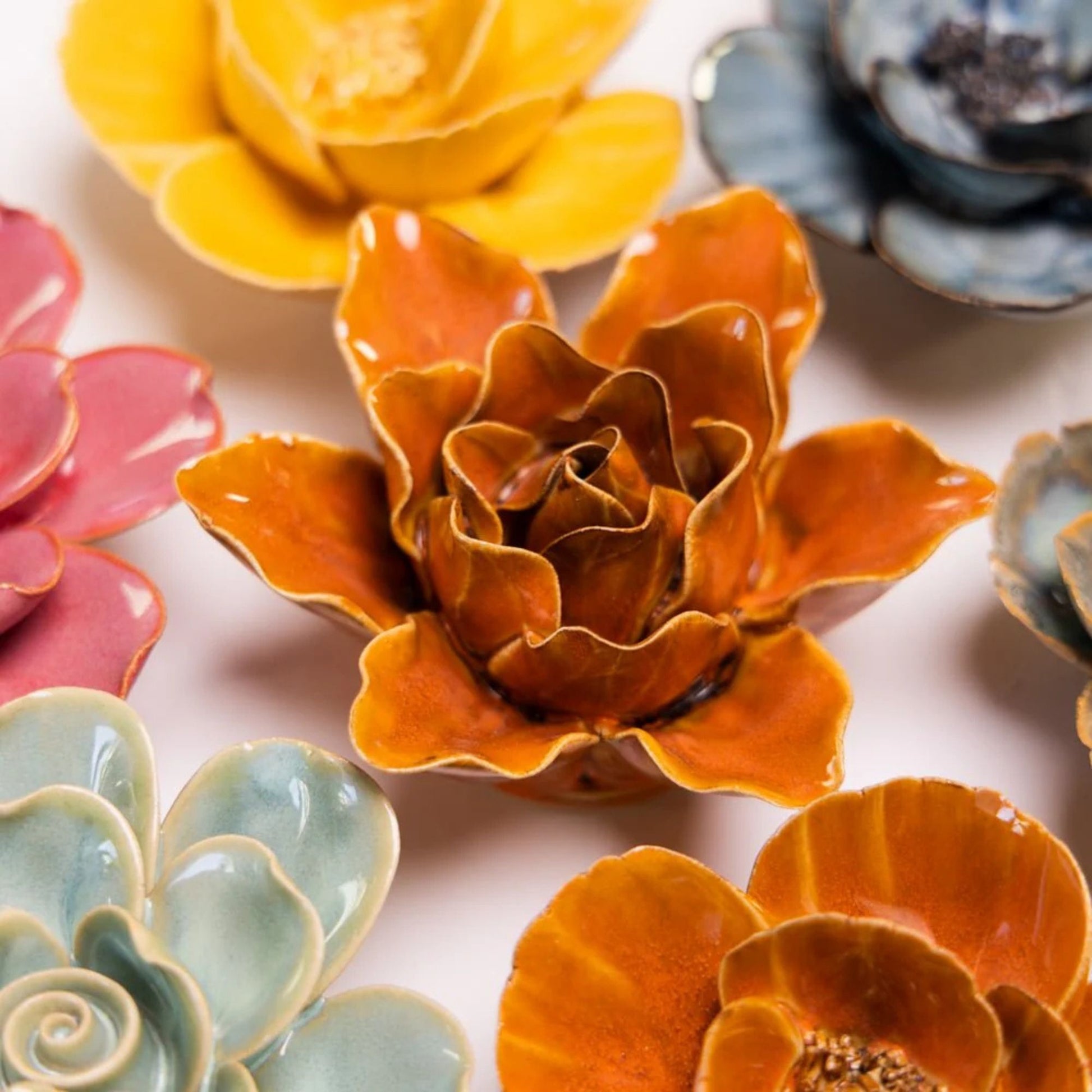 Colourful ceramic flower-shaped flowers on a light background