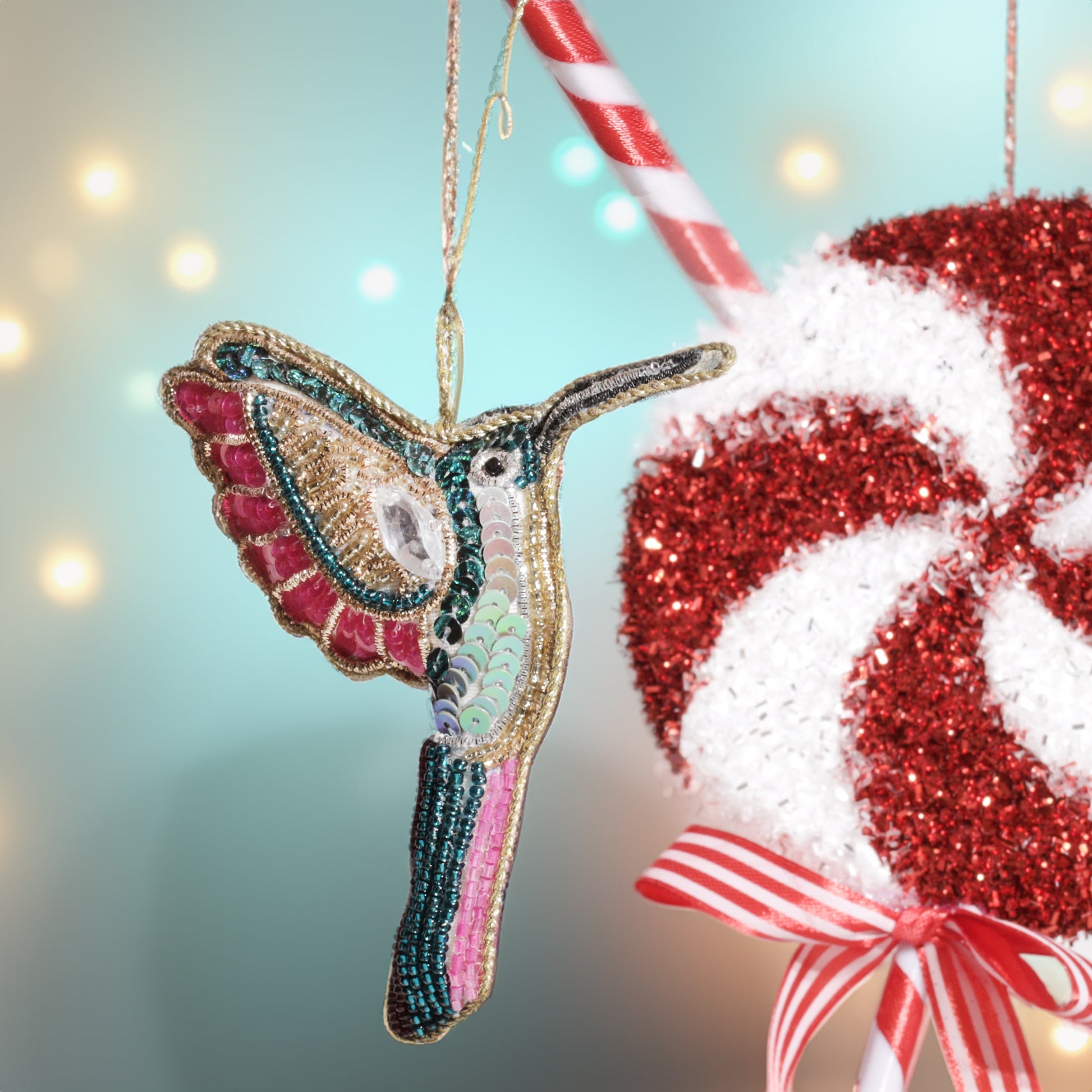Decorative hummingbird ornament with a candy cane against a blurred light background