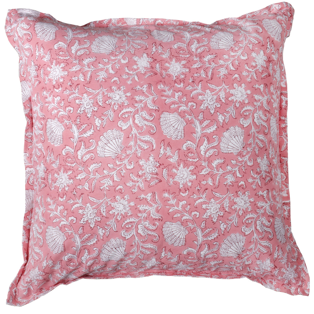 A square cushion with a pink base, featuring intricate white floral and seashell block print patterns. The edges are softly flanged, adding texture and detail to the design.