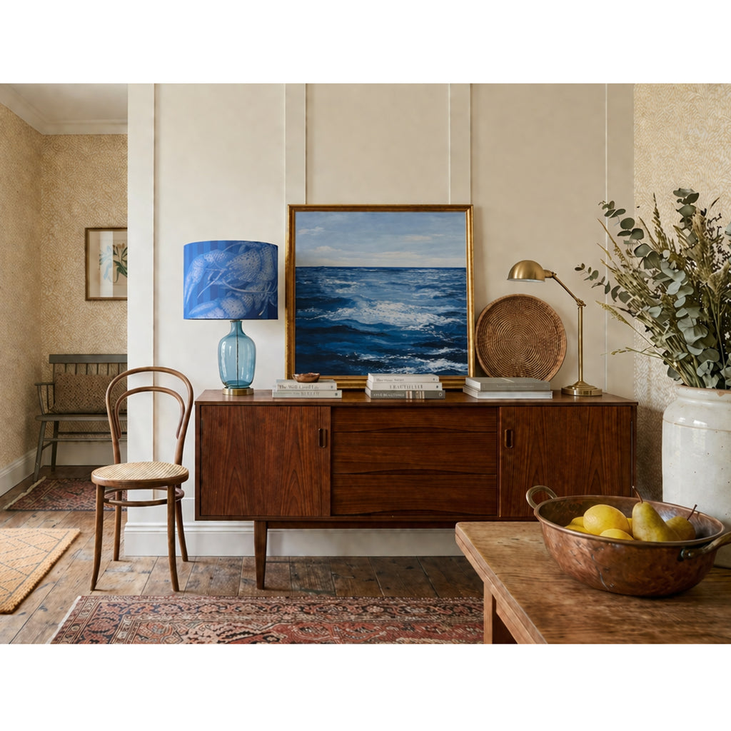 Living room with wooden sideboard, lamp, and decor items.