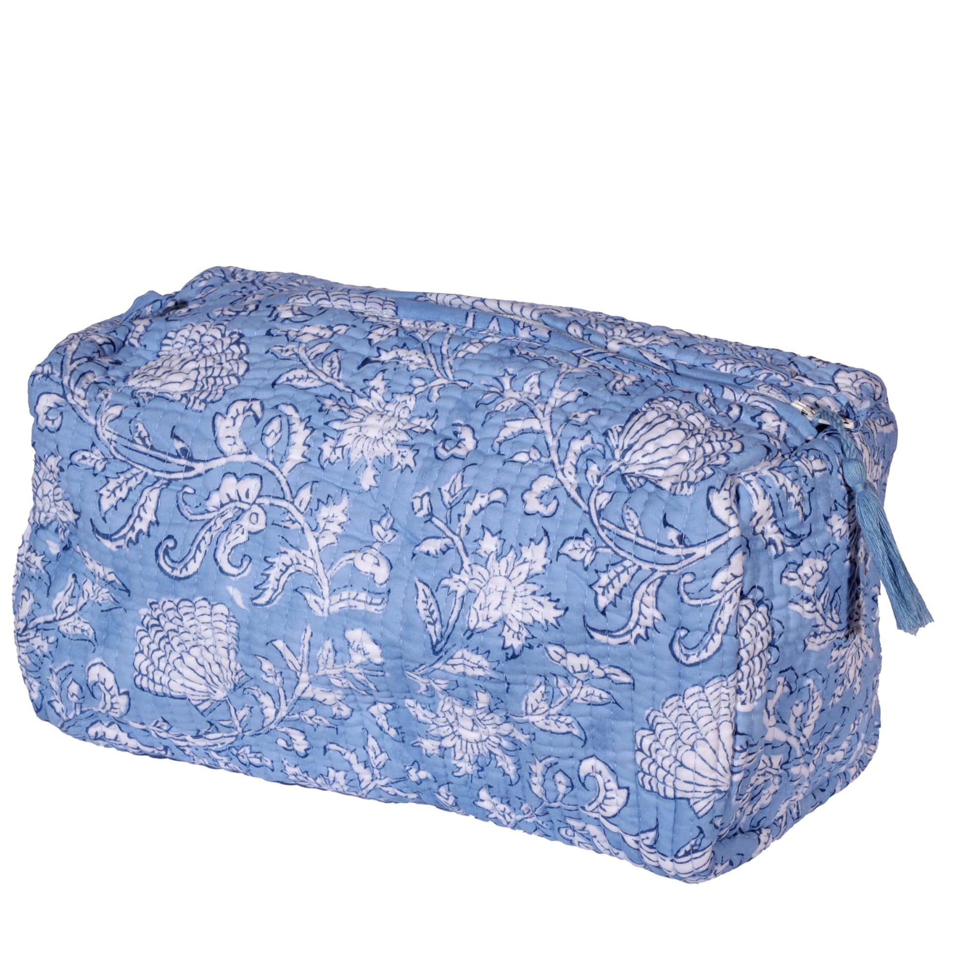 Light blue rectangular washbag featuring intricate white floral block print patterns. The bag is quilted for texture and includes a tassel detail on the zipper for added charm.