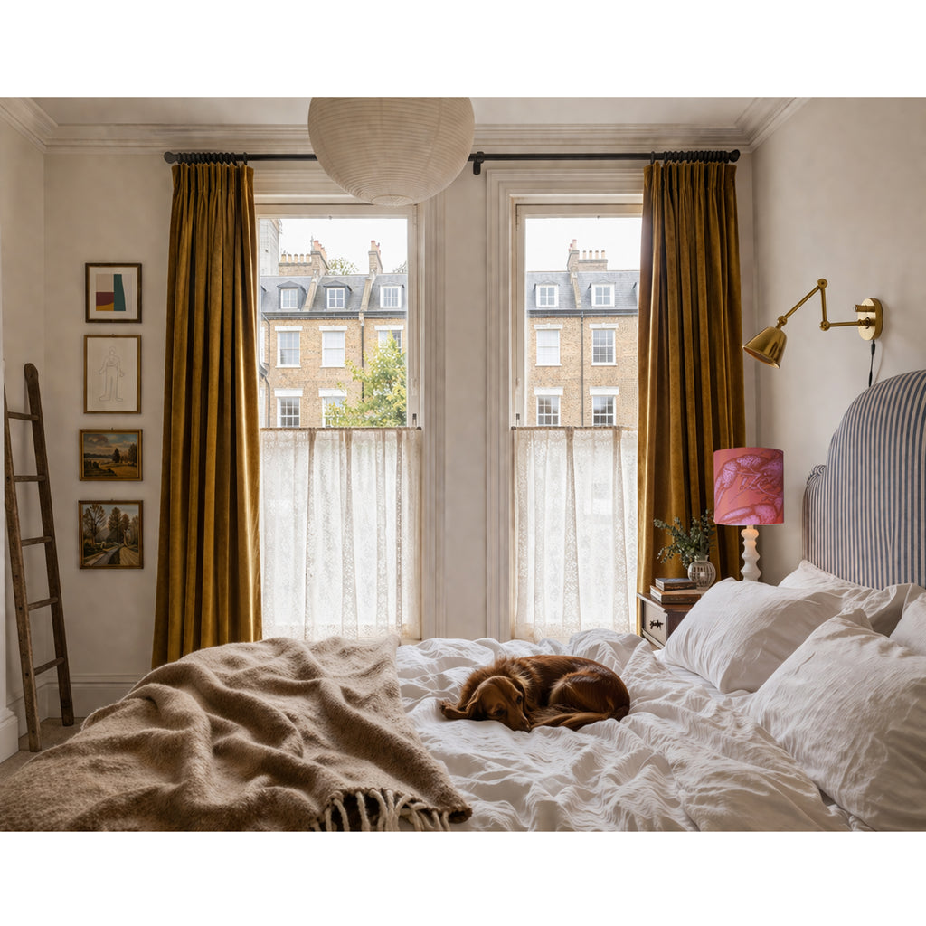 Cozy bedroom with a dog resting on the bed, large windows, and decorative elements.
