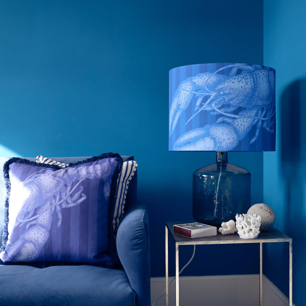 Blue-themed living room with a lamp and decorative items against a blue wall.