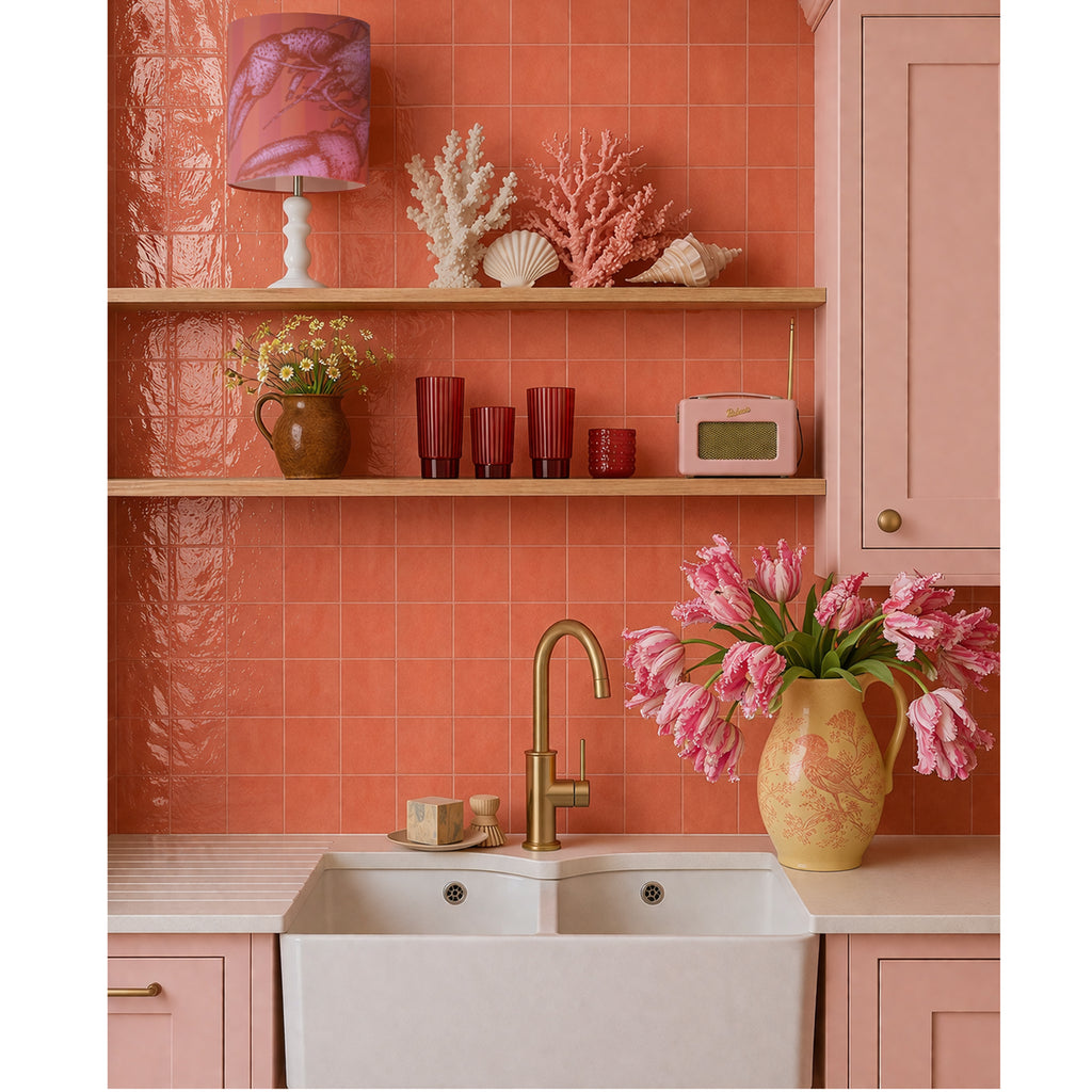 Pink kitchen with coral tiles, a sink, and decorative elements.