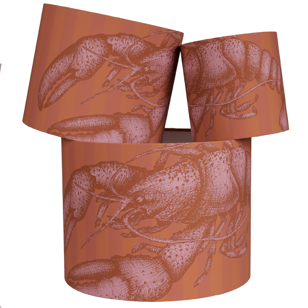 Set of three cylindrical lampshades with lobster design on a white background