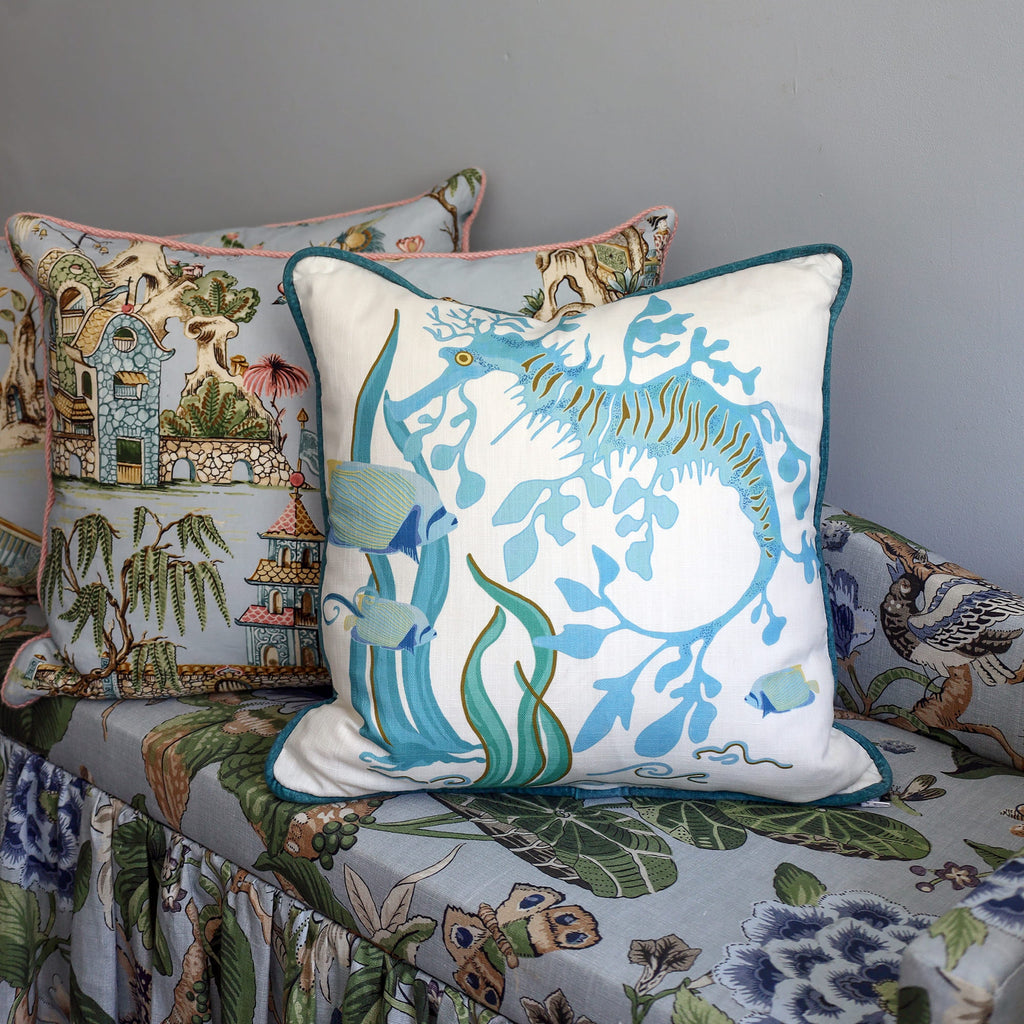 Cream Cornwall Sea Horse cushion styled on a patterned armchair, bringing soft coastal blues and seaside charm to an eclectic interior.