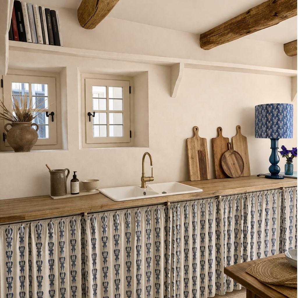 Kitchen with wooden counter, sink, and patterned fabric on the wall.