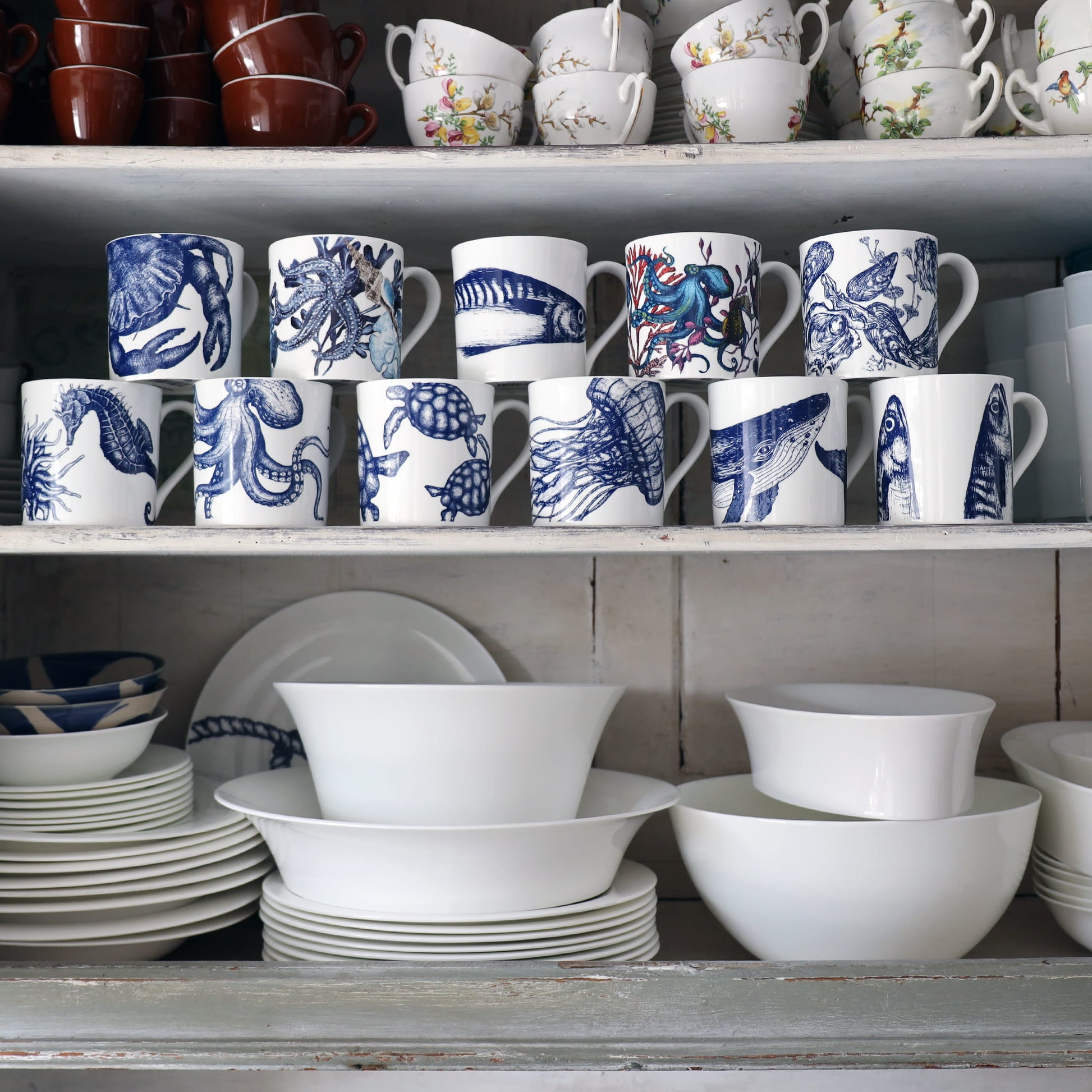 Shelves with ceramic mugs and bowls featuring blue and white designs.